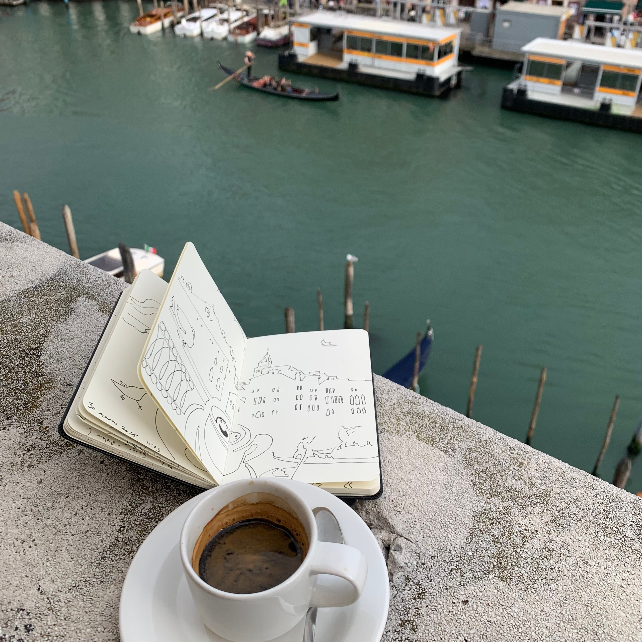 Moleskine notebook with hand-drawn sketches made in Venice, serving as an artist’s visual diary and personal testimony within a contemporary practice. A coffee cup alongside a Moleskine notebook with a view on Canal Grande.
