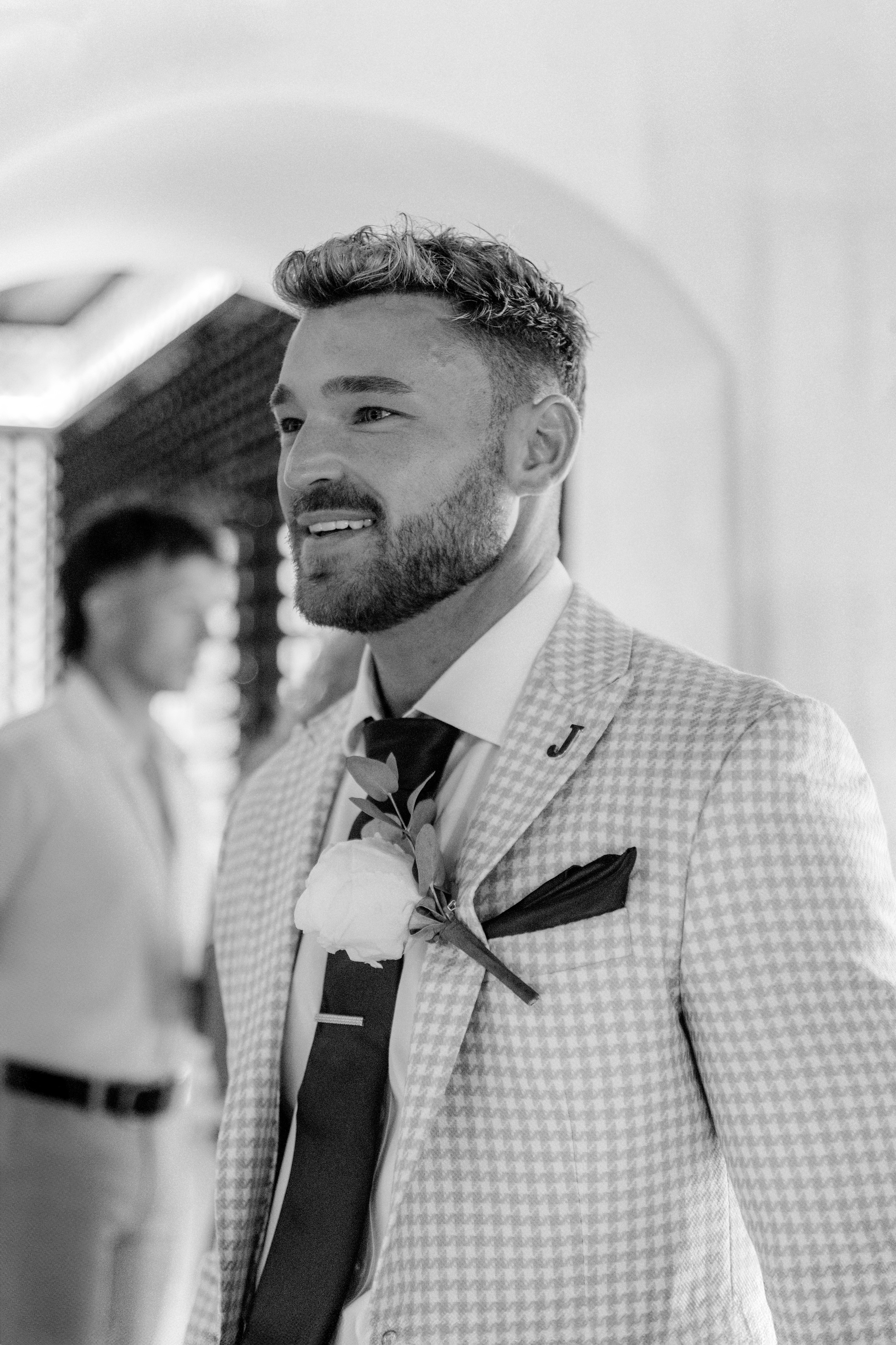 Groom's friend is posing for a photo at a pre-wedding party in a traditional Greek bar in Lindos