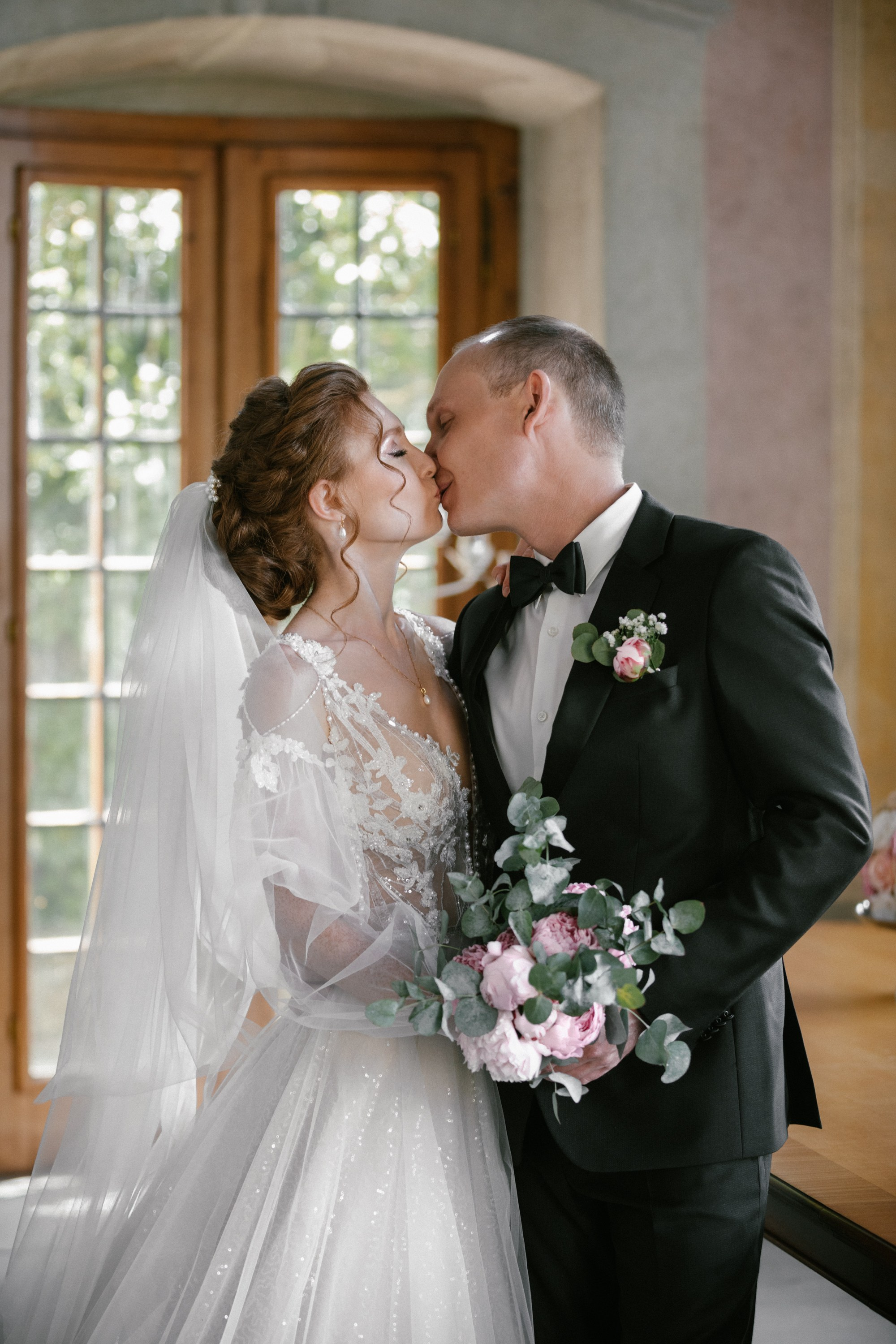 Braut küsst Bräutigam mit Pfingstrosenstrauß im Teehaus Schloss Meersburg