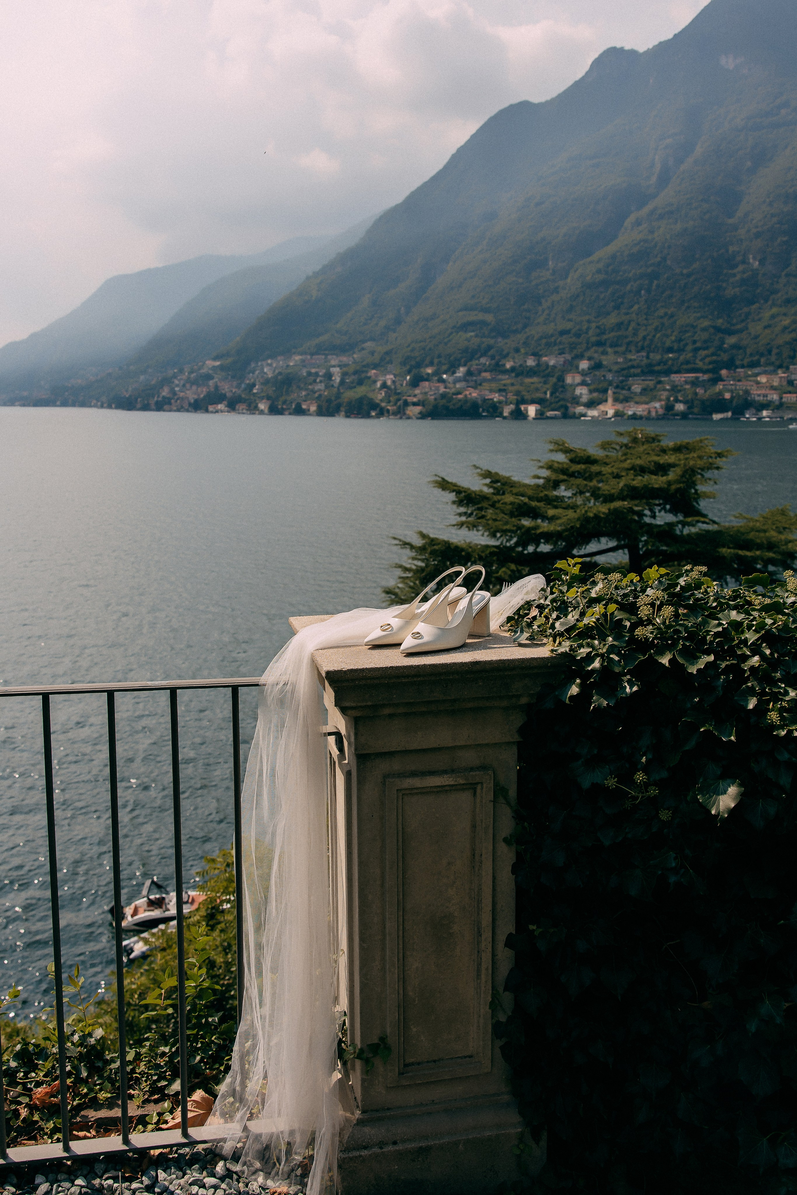 Black and white photo of a groom helping the bride get ready at Villa Lario, Lake Como, Italy