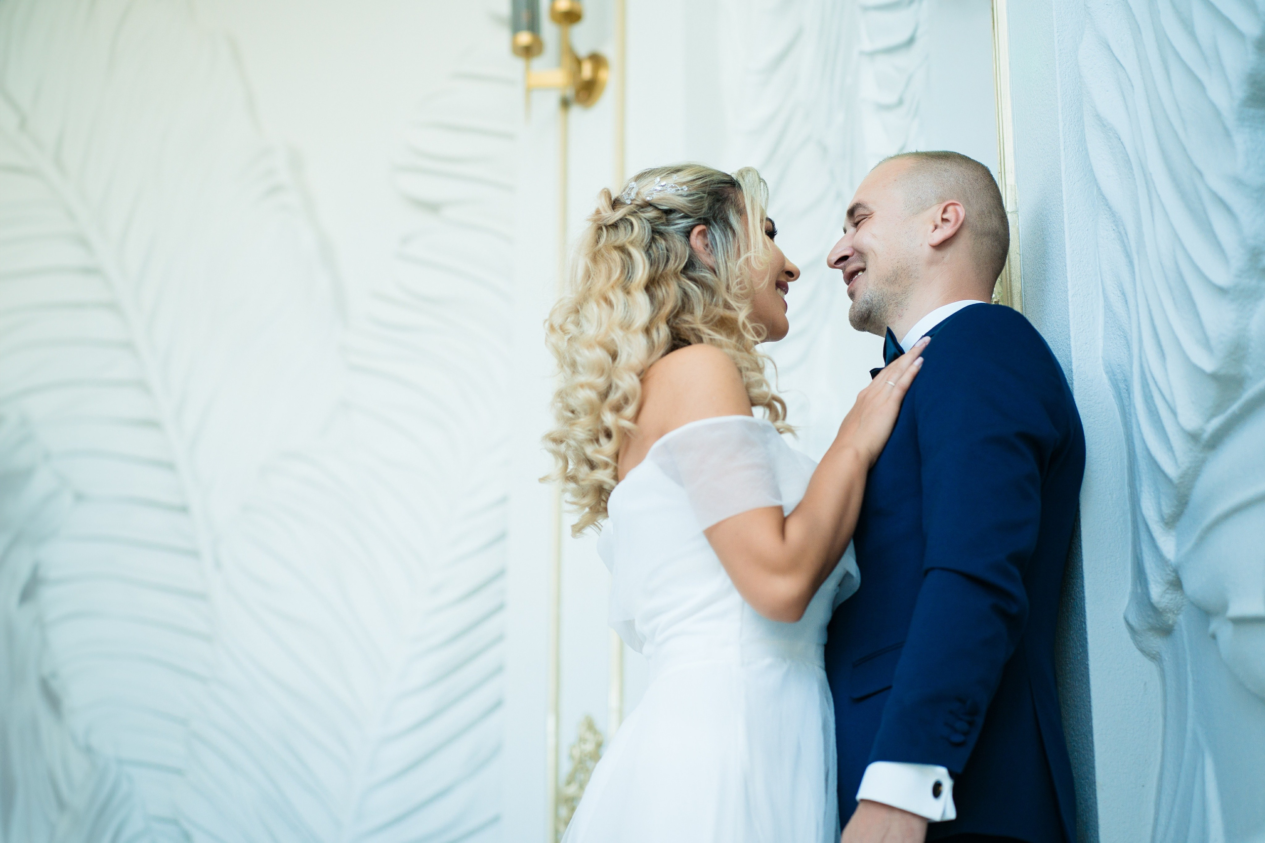 Mireasa râzând în brațele mirelui, într-un peisaj de poveste