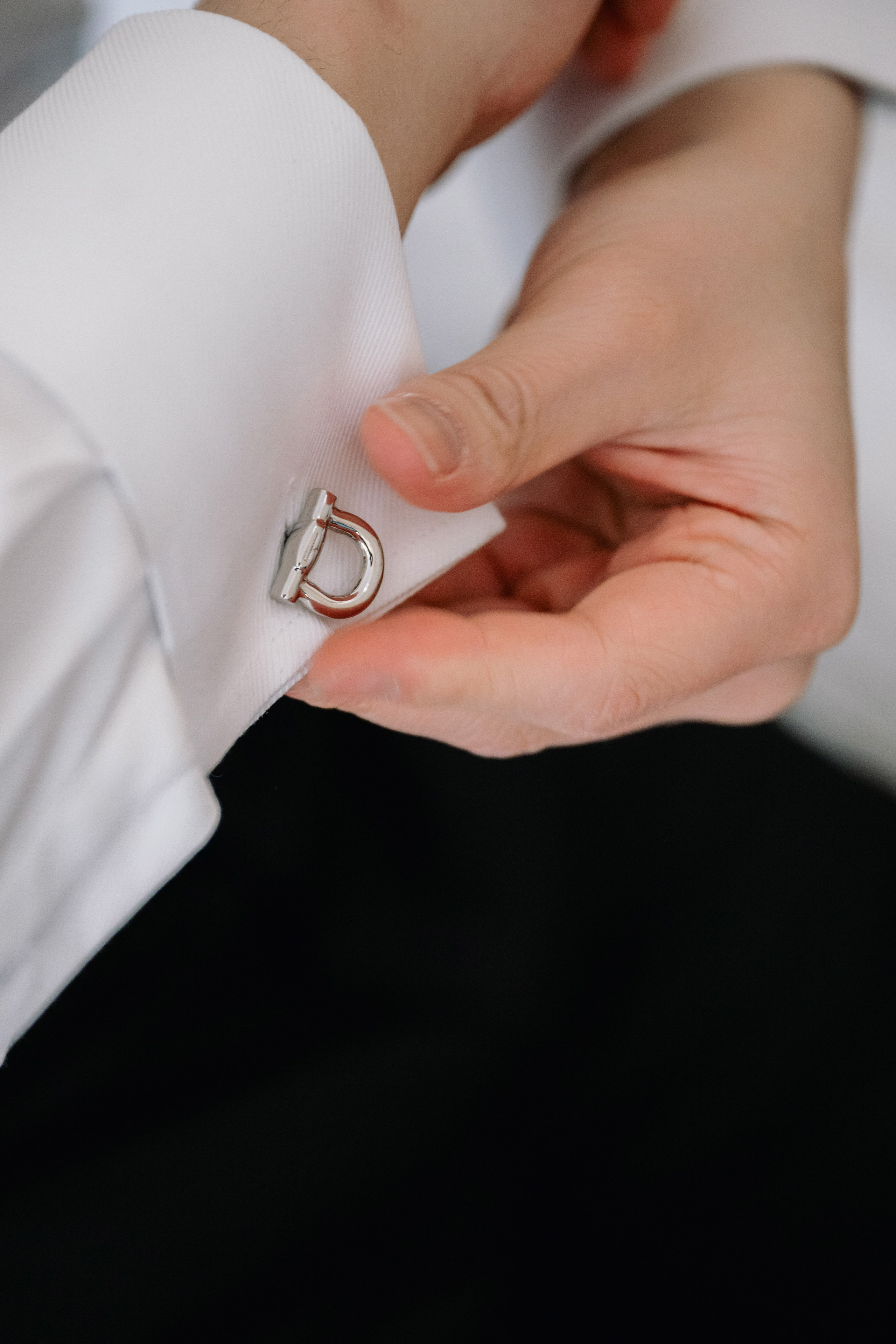 a man in a white shirt is putting a ring on his finger