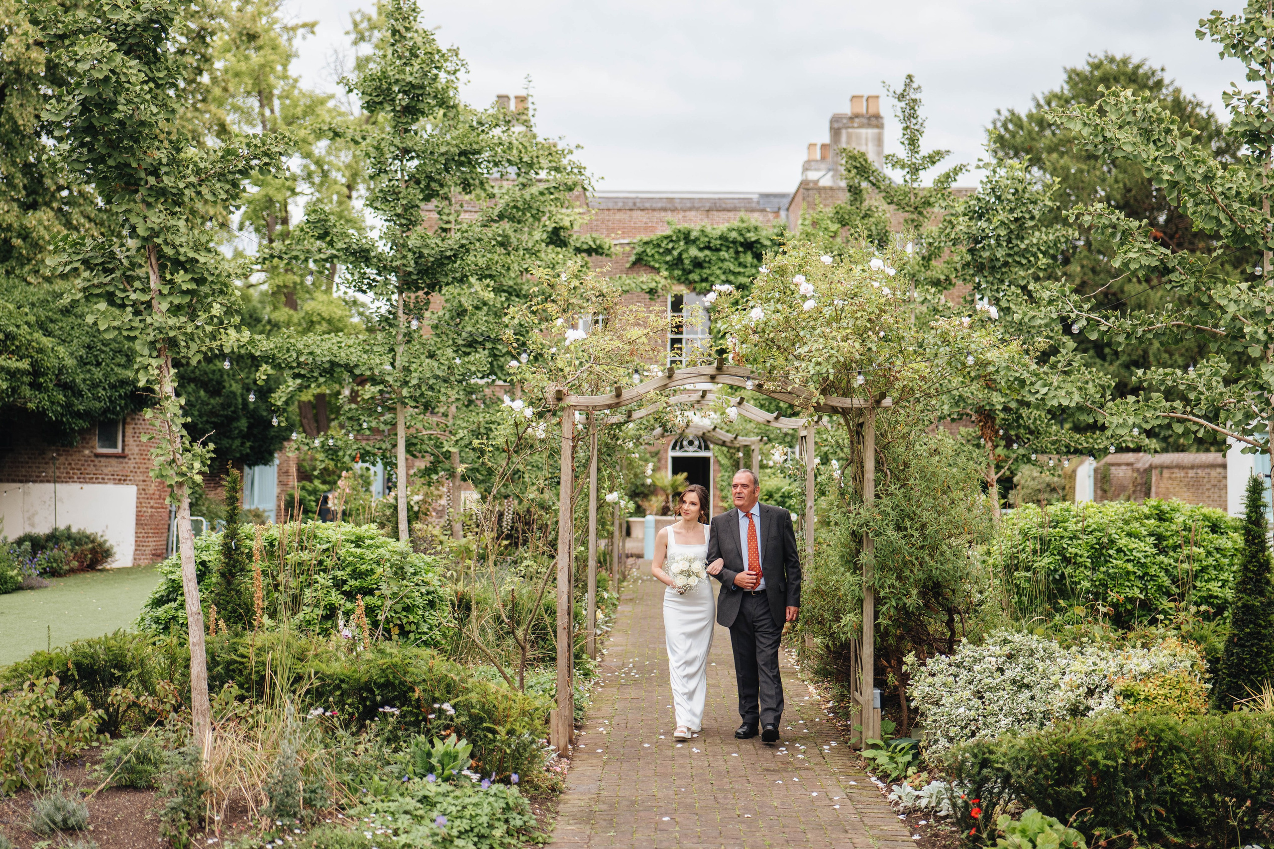 bride walking through the venue with her father, wider look