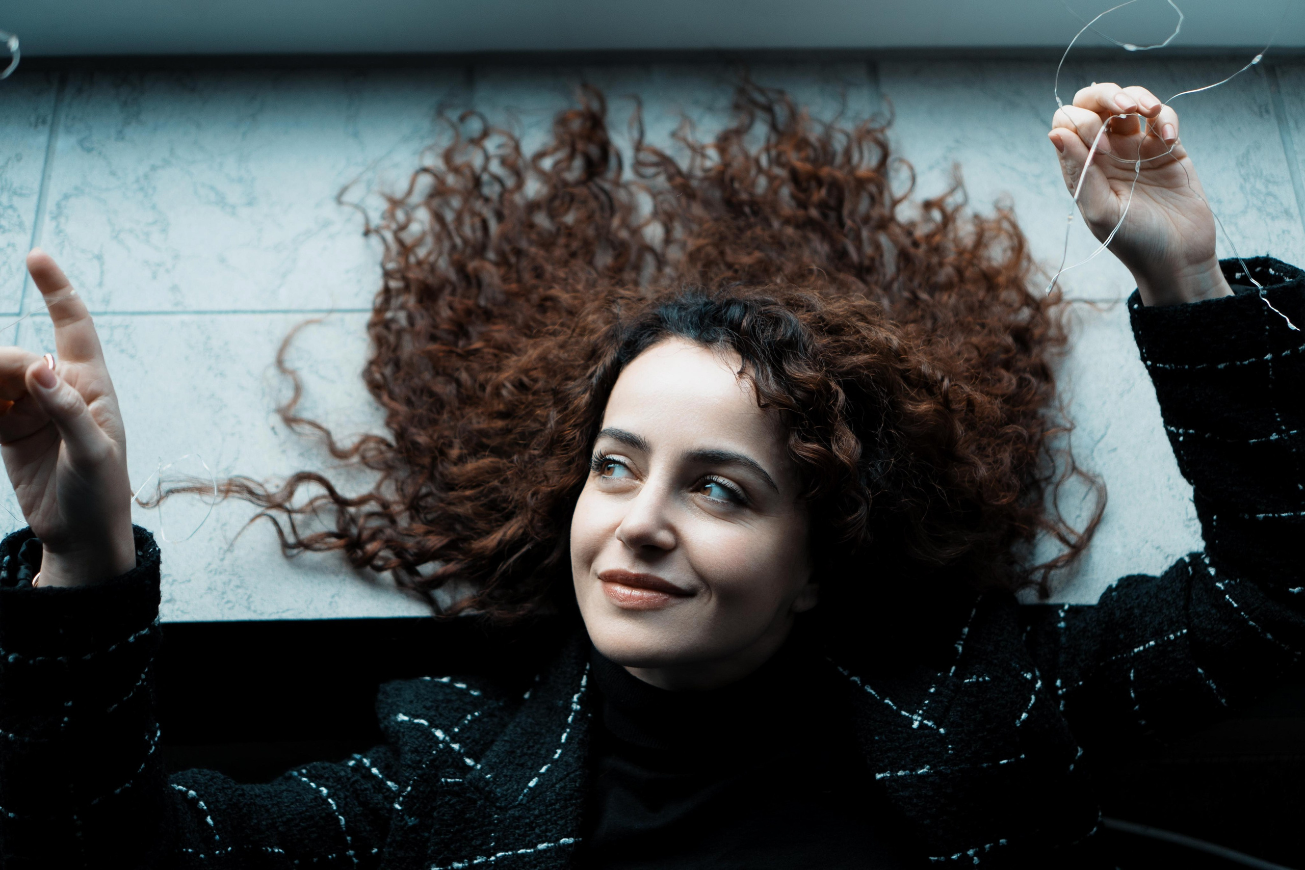 Von oben, lockige Haare fächerförmig – verspieltes Studio-Portrait