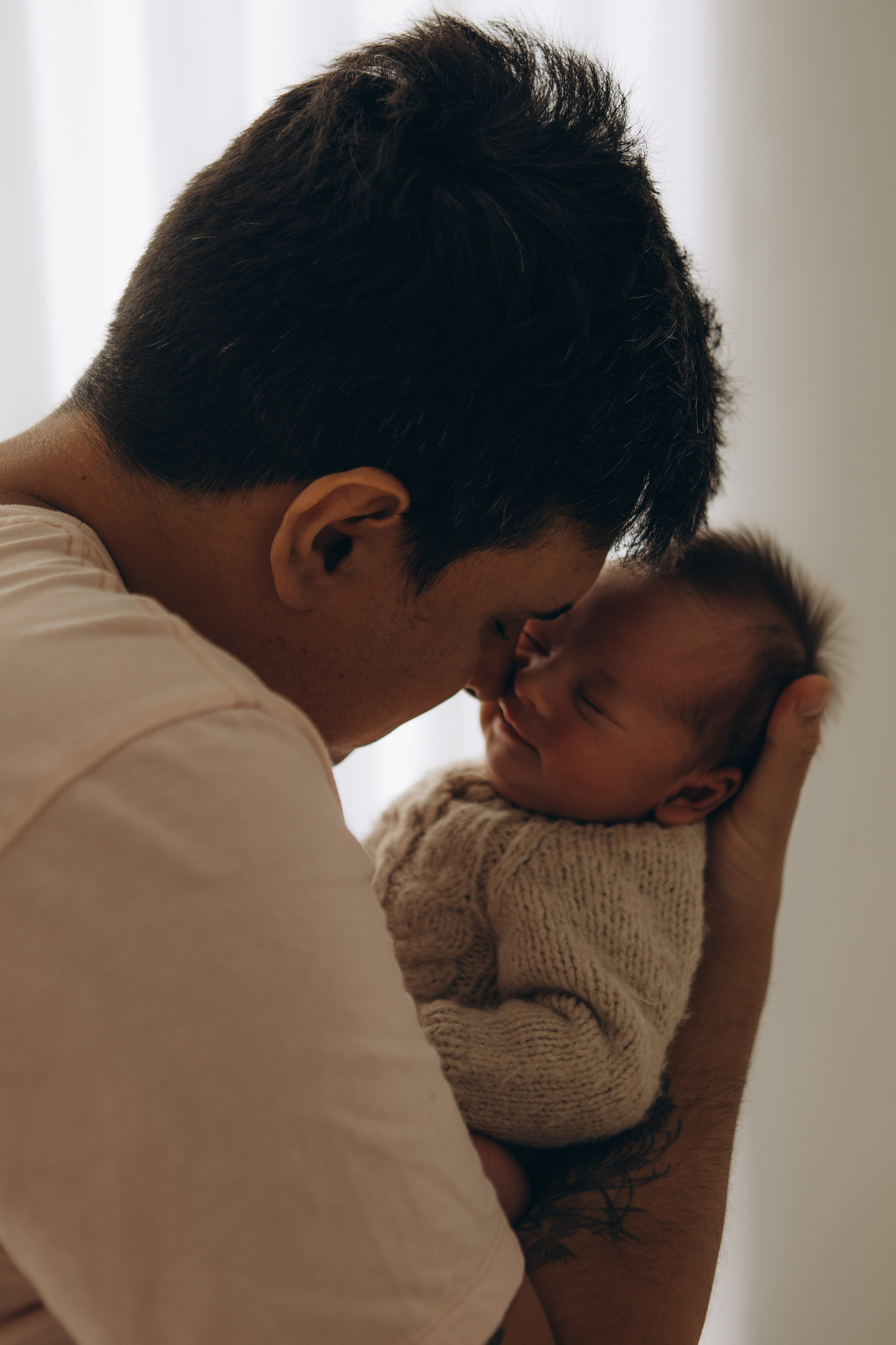 pai com bebê no colo em ensaio newborn com luz natural em Sorocaba