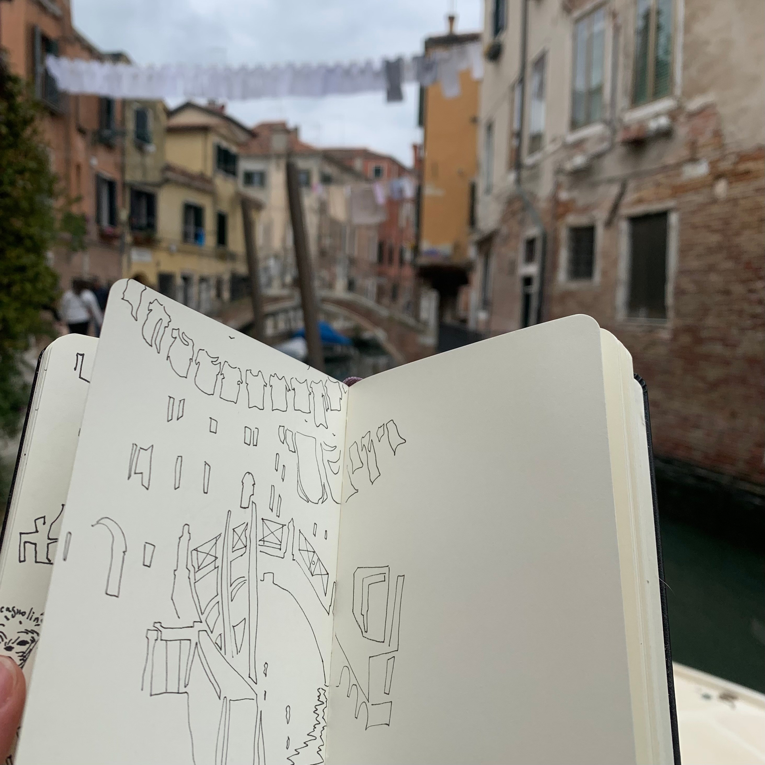 Moleskine notebook with original hand-drawn works on paper created in Venice, part of Nadia Kuprina’s contemporary drawing practice. A photo of a drawing on a Venetian street.