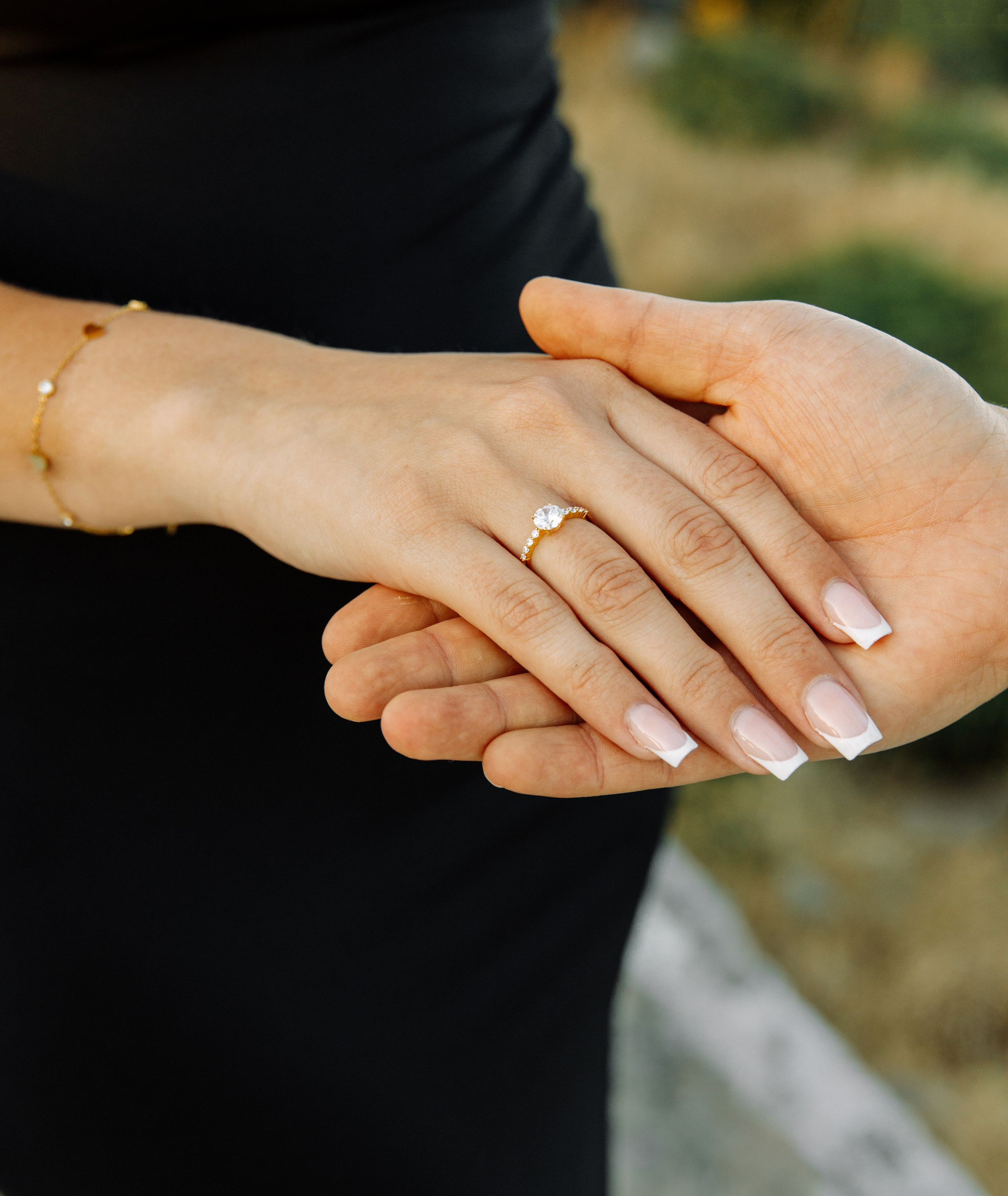 "Close-up der Hände nach dem Heiratsantrag auf dem Profitis Ilias: Ein strahlender Verlobungsring vor der malerischen Kulisse von Rhodos und dem azurblauen Meer."