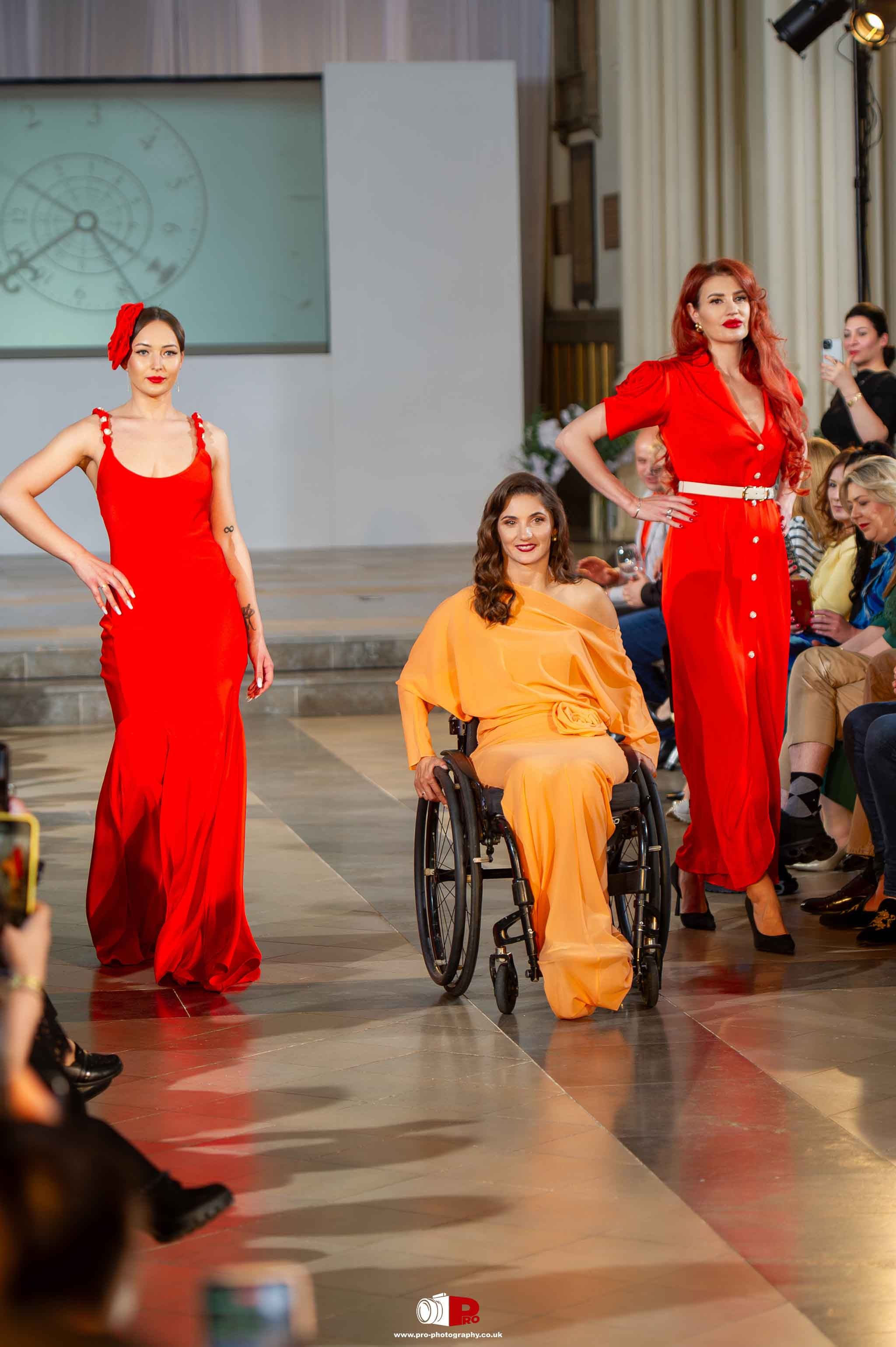 Three models, including one in a wheelchair, proudly walked down the runway in bright red and orange outfits.