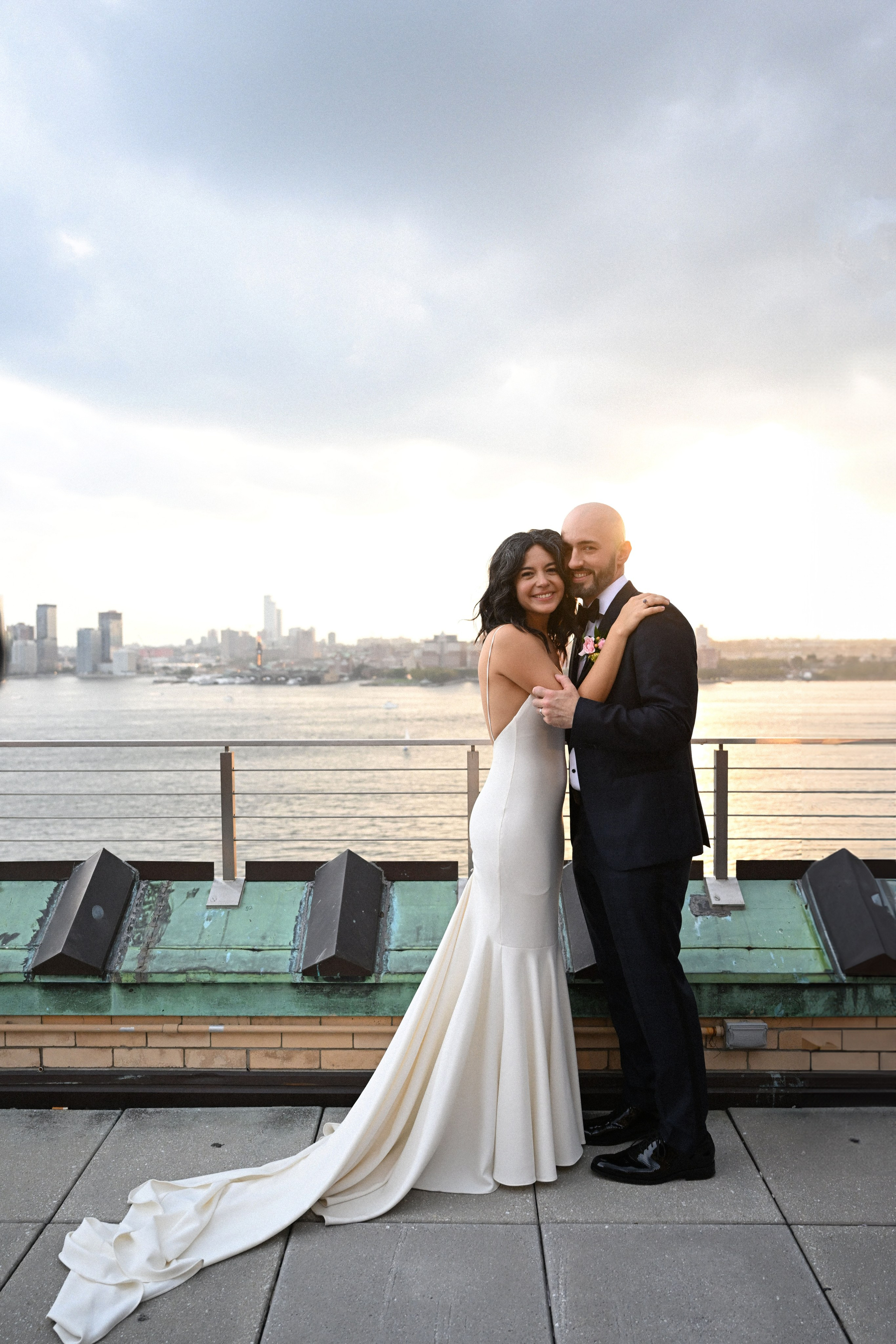 a bride and groom kissing on a pier