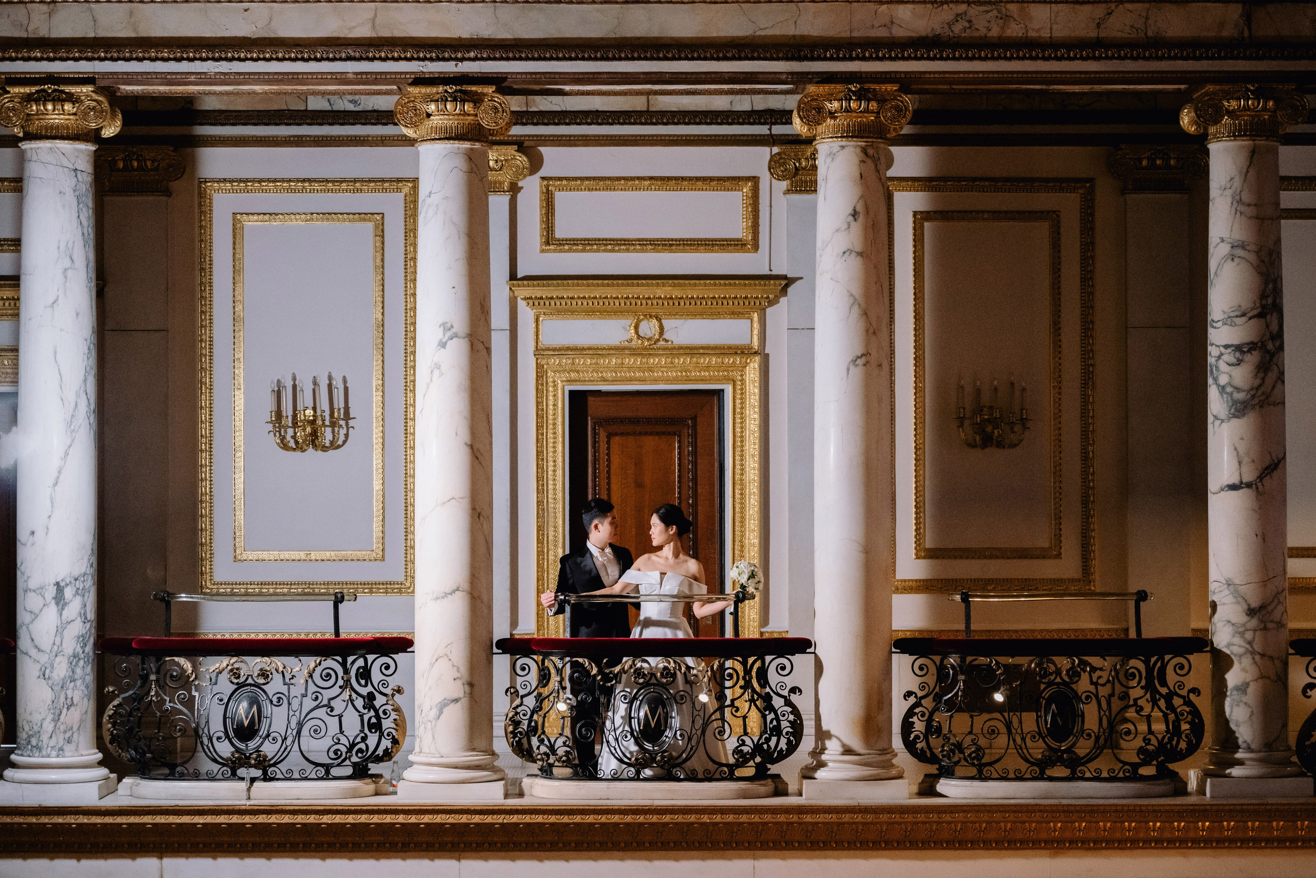 a bride and groom sitting on a balcony