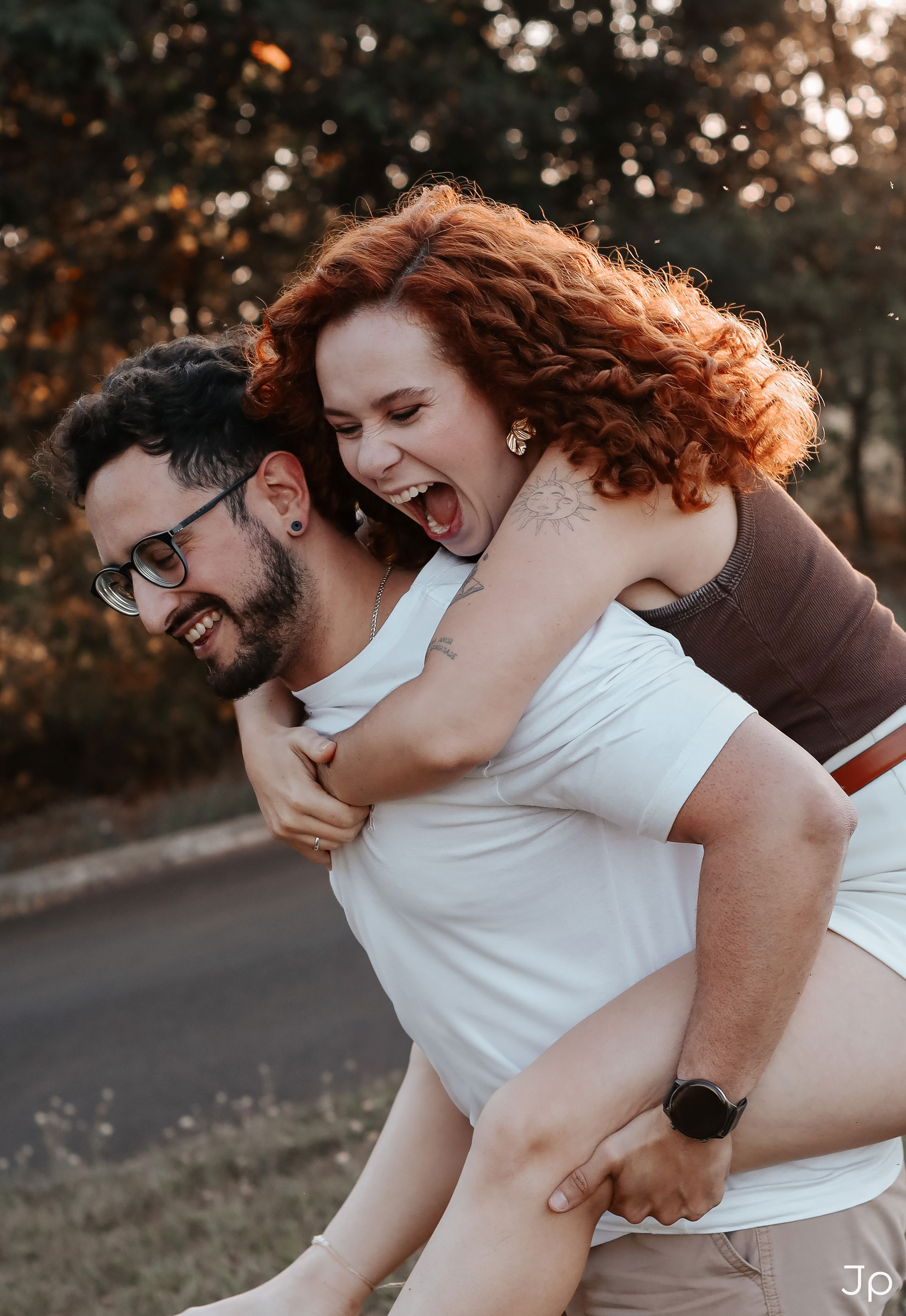 Ela dá risada enquanto é carregada nas costas por ele.