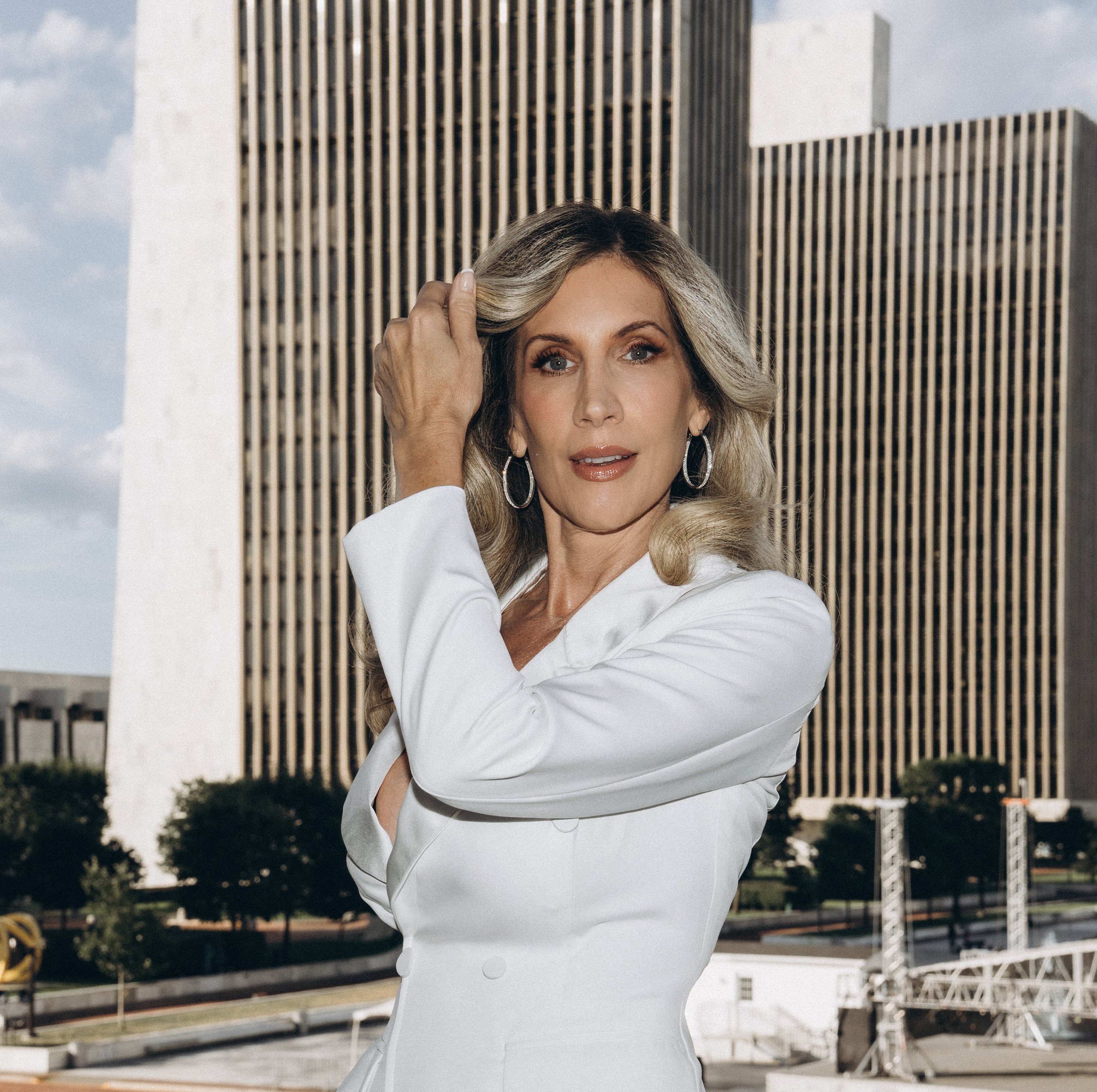 Bride in lace gown near Lake Placid mountain view.
