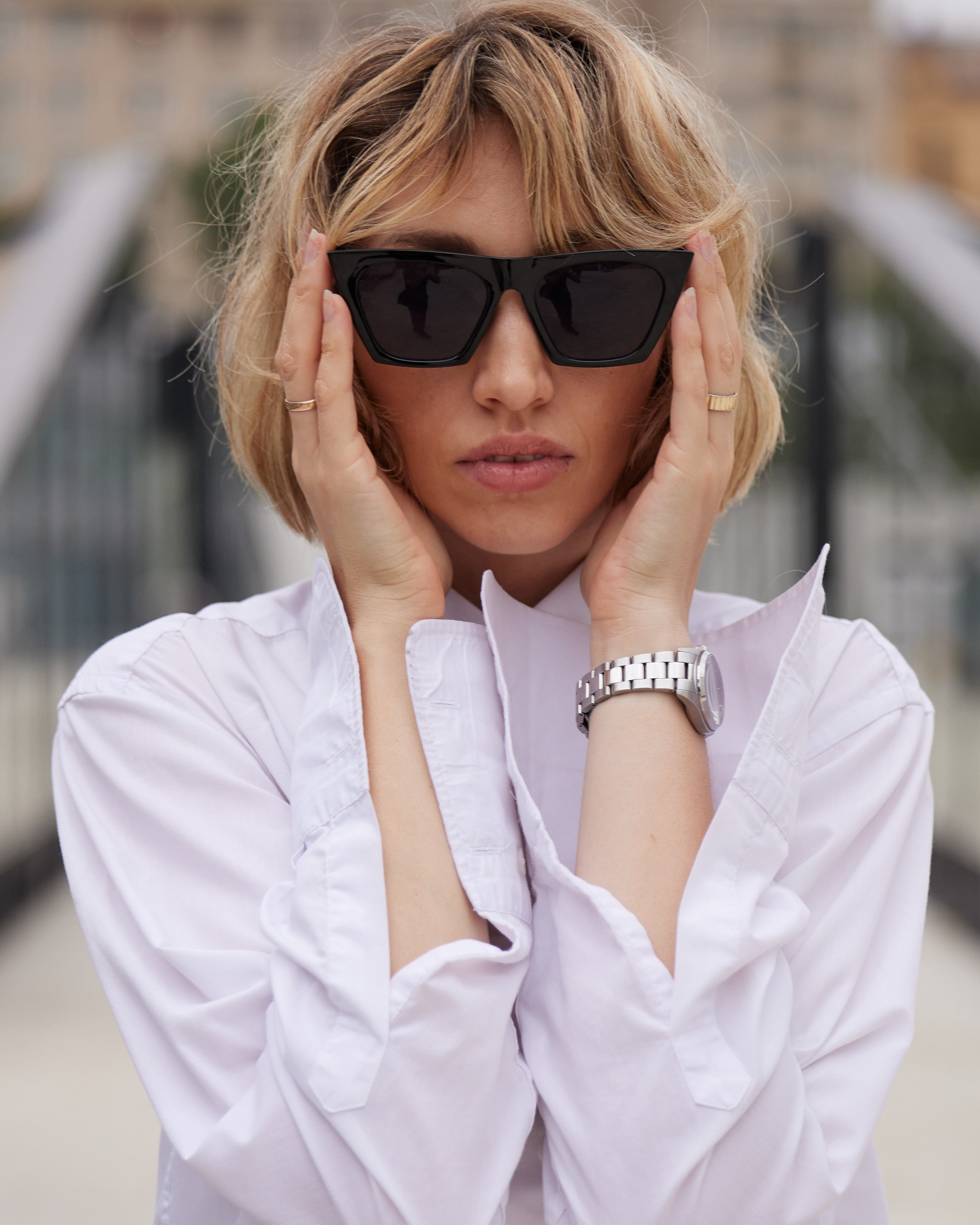 Location portrait of a young woman in sunglasses against the backdrop of a building - photographer Andrey Dunin