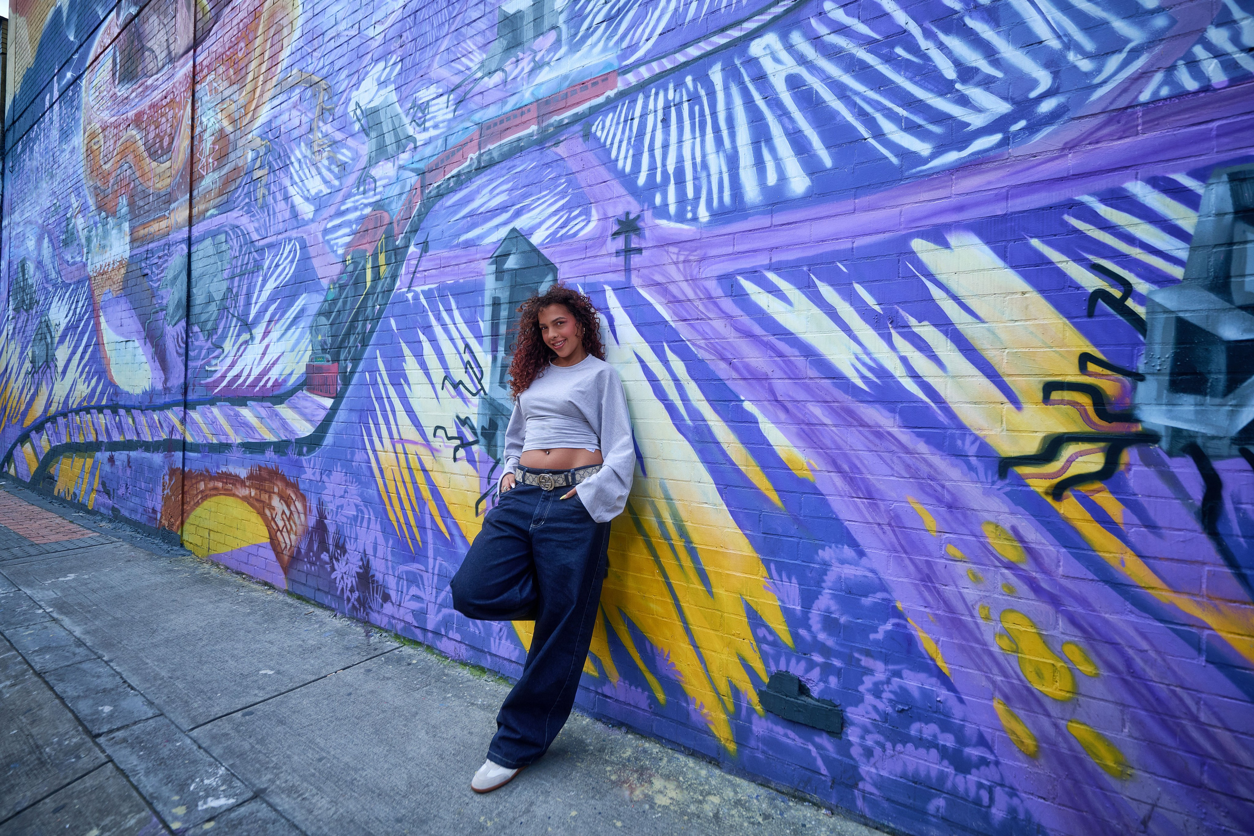 Sesión de fotos urbana de Ivanna con fondo de arte callejero y graffitis vibrantes.