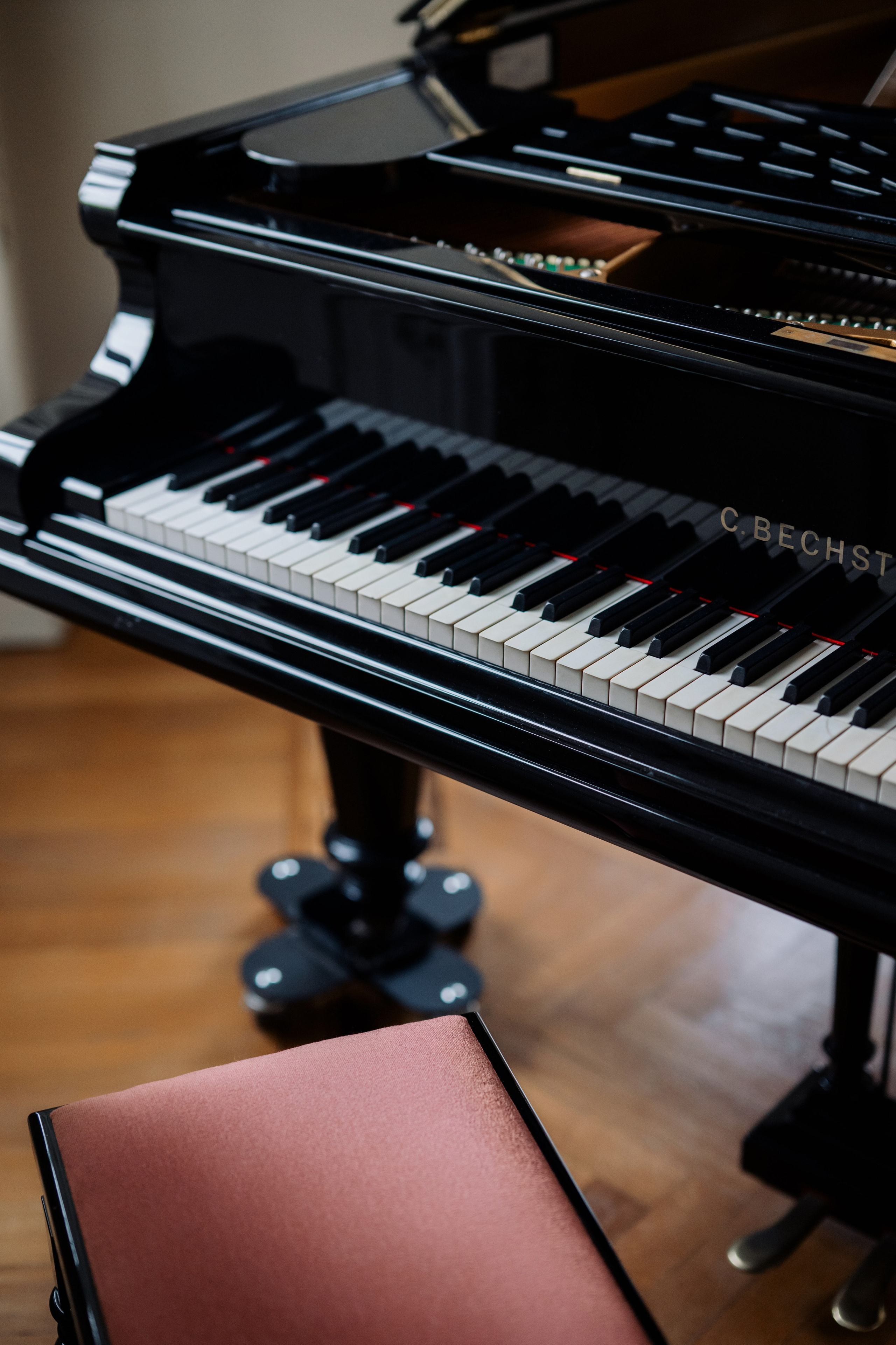 a black piano with a red seat