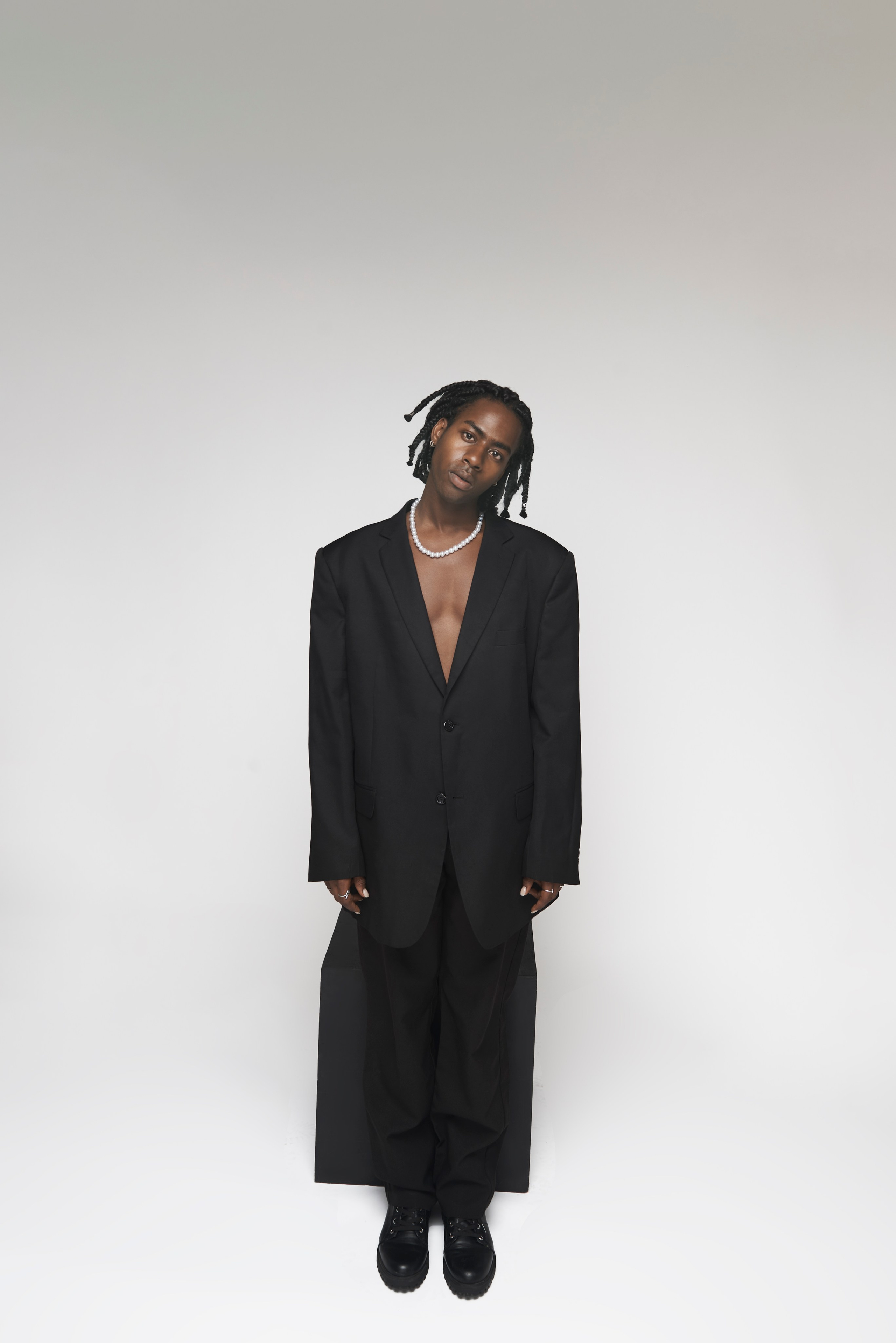 Minimalist portrait of a man in an oversized black blazer