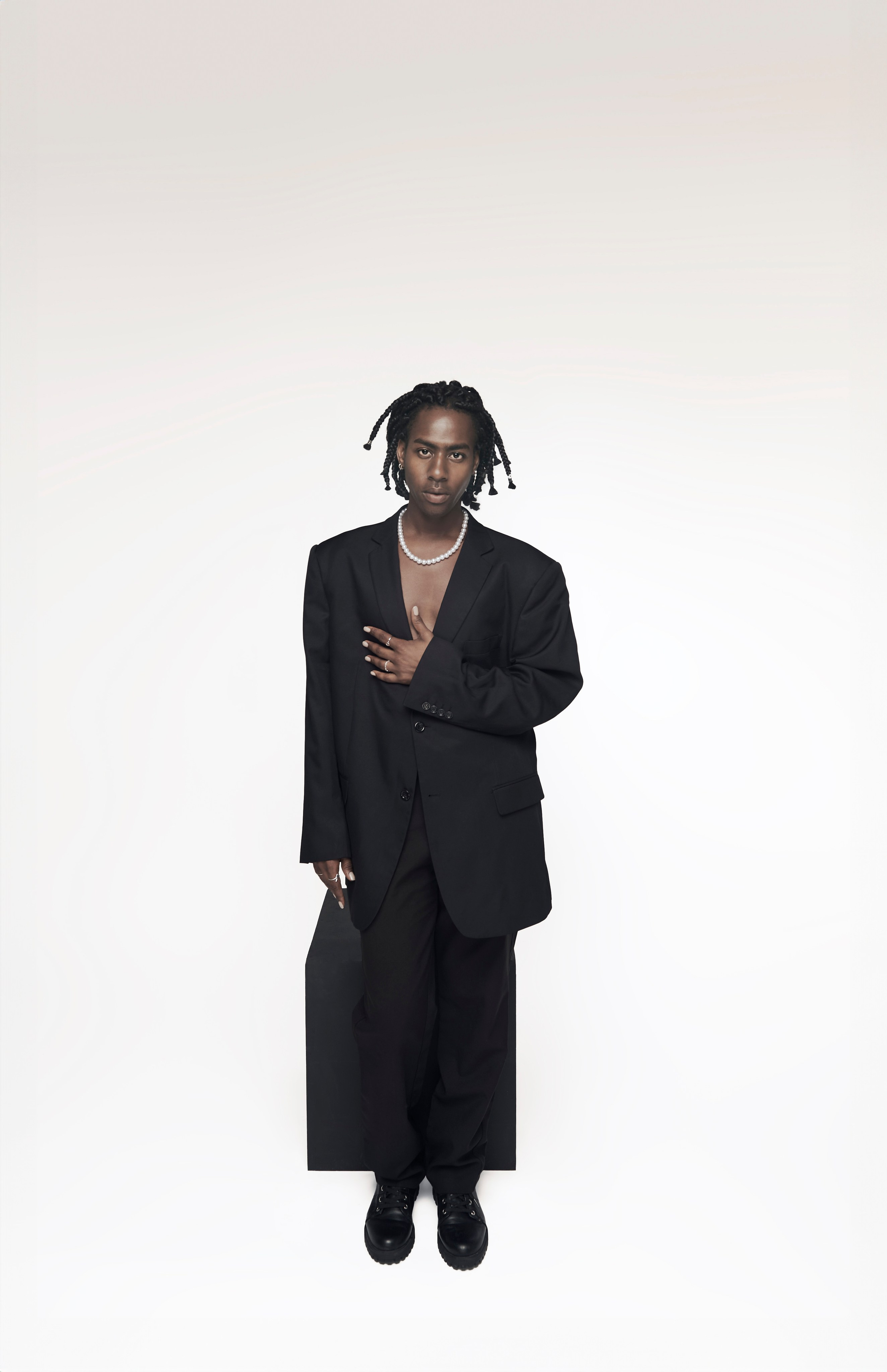 Full-body shot of a singer in a minimalist black outfit