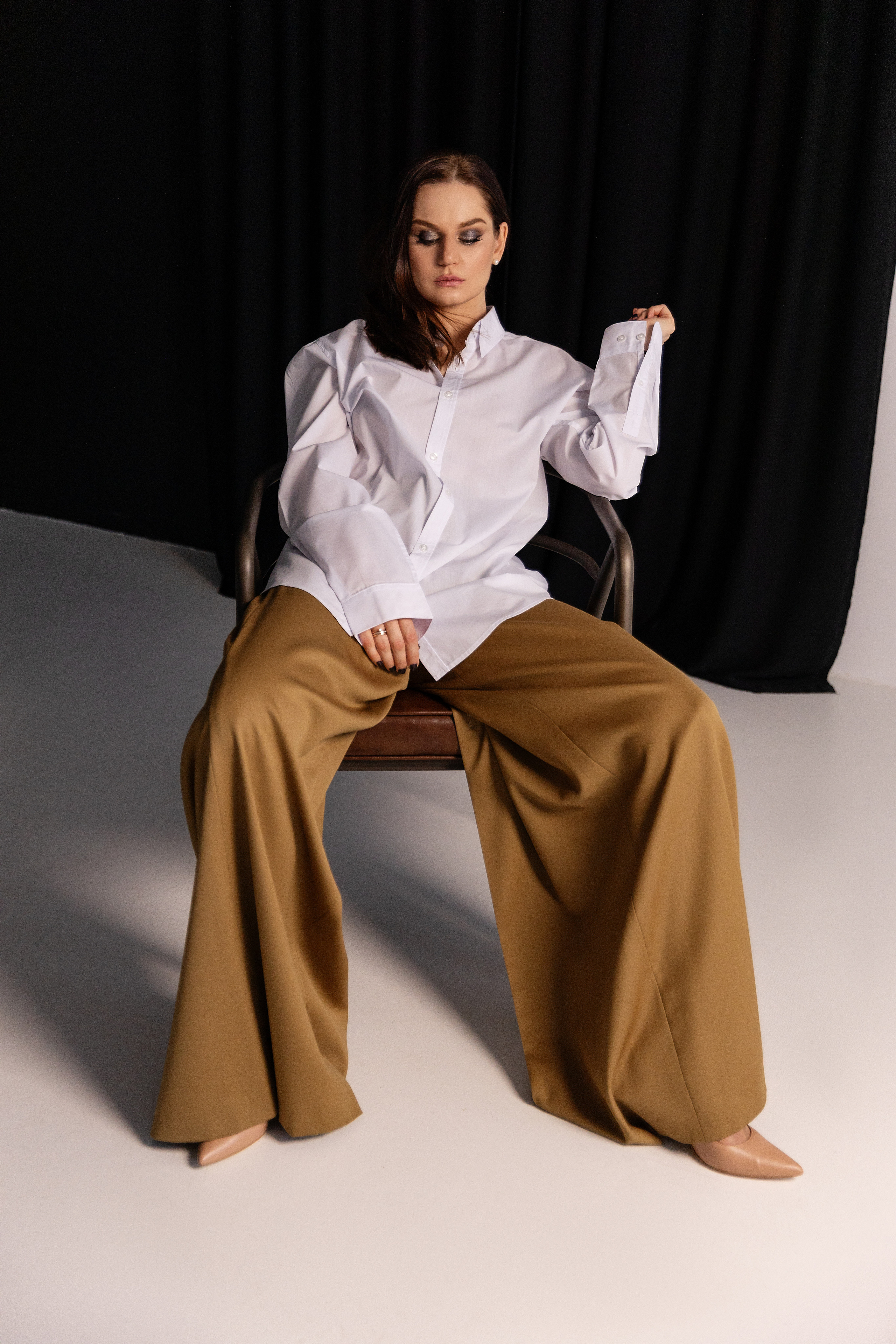 Девушка сидит на стуле в студии, портретная съемка 