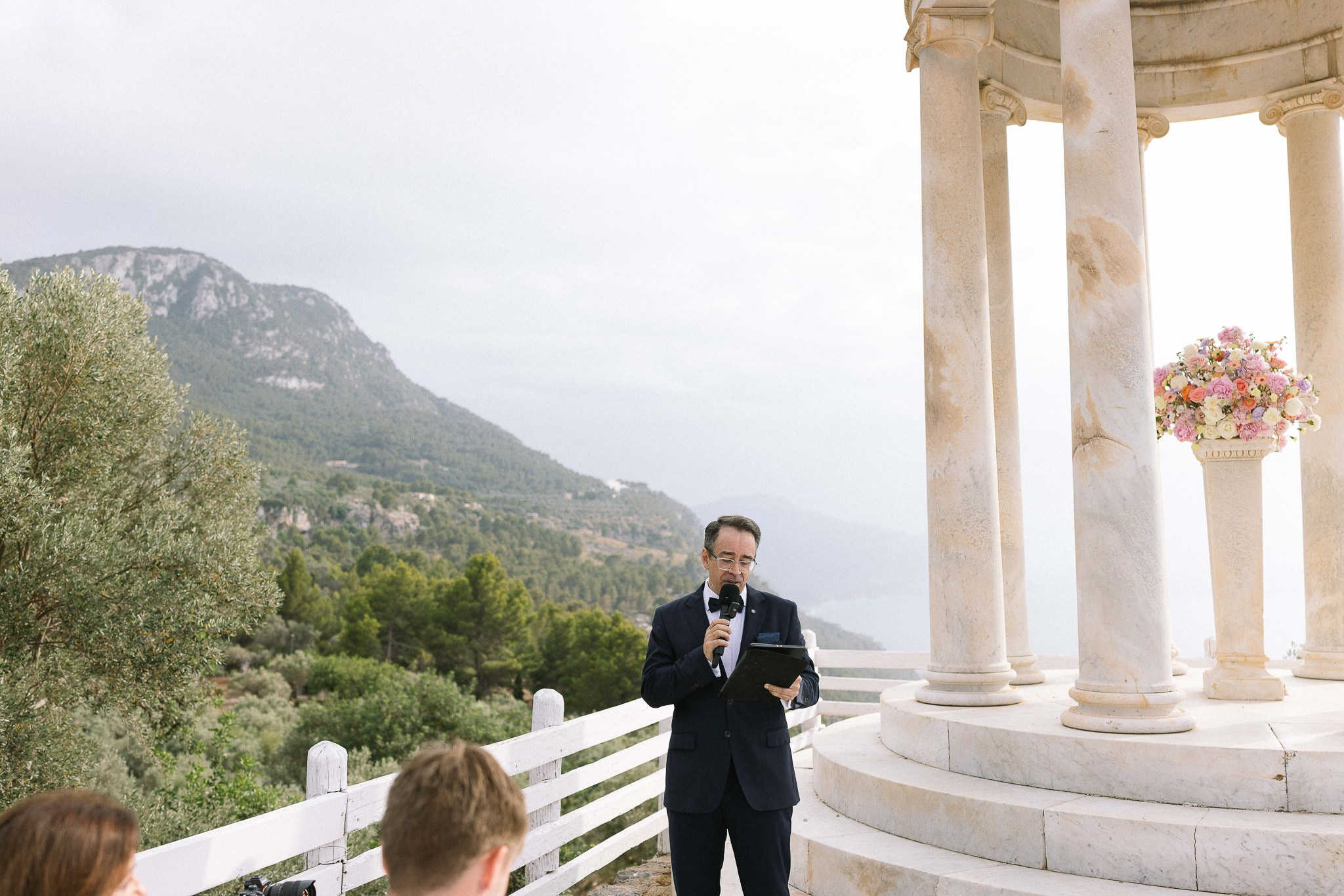 Wedding officiant reading ceremony overlooking Mallorca coastline