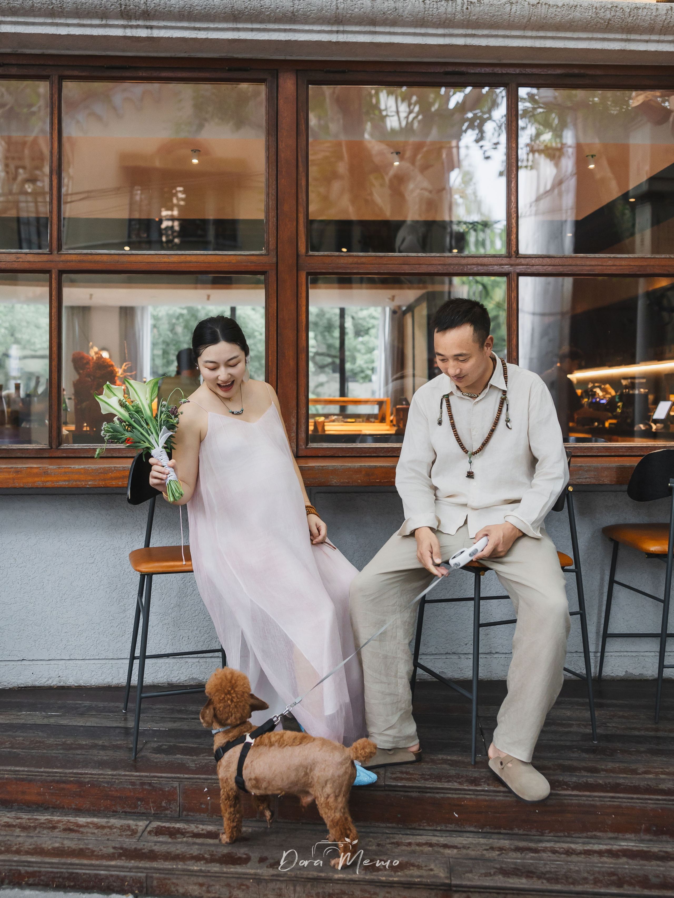 Expecting parents sitting outside a café with their dog, photographed by a Shanghai family photographer capturing calm everyday moments.