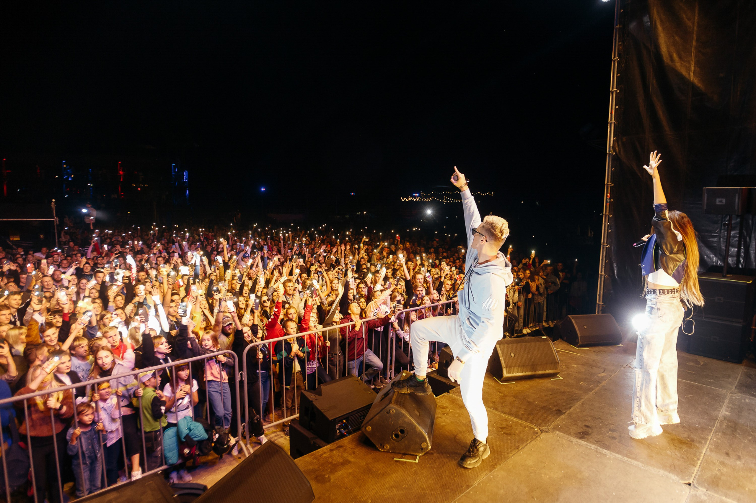 Performer on stage with large cheering crowd