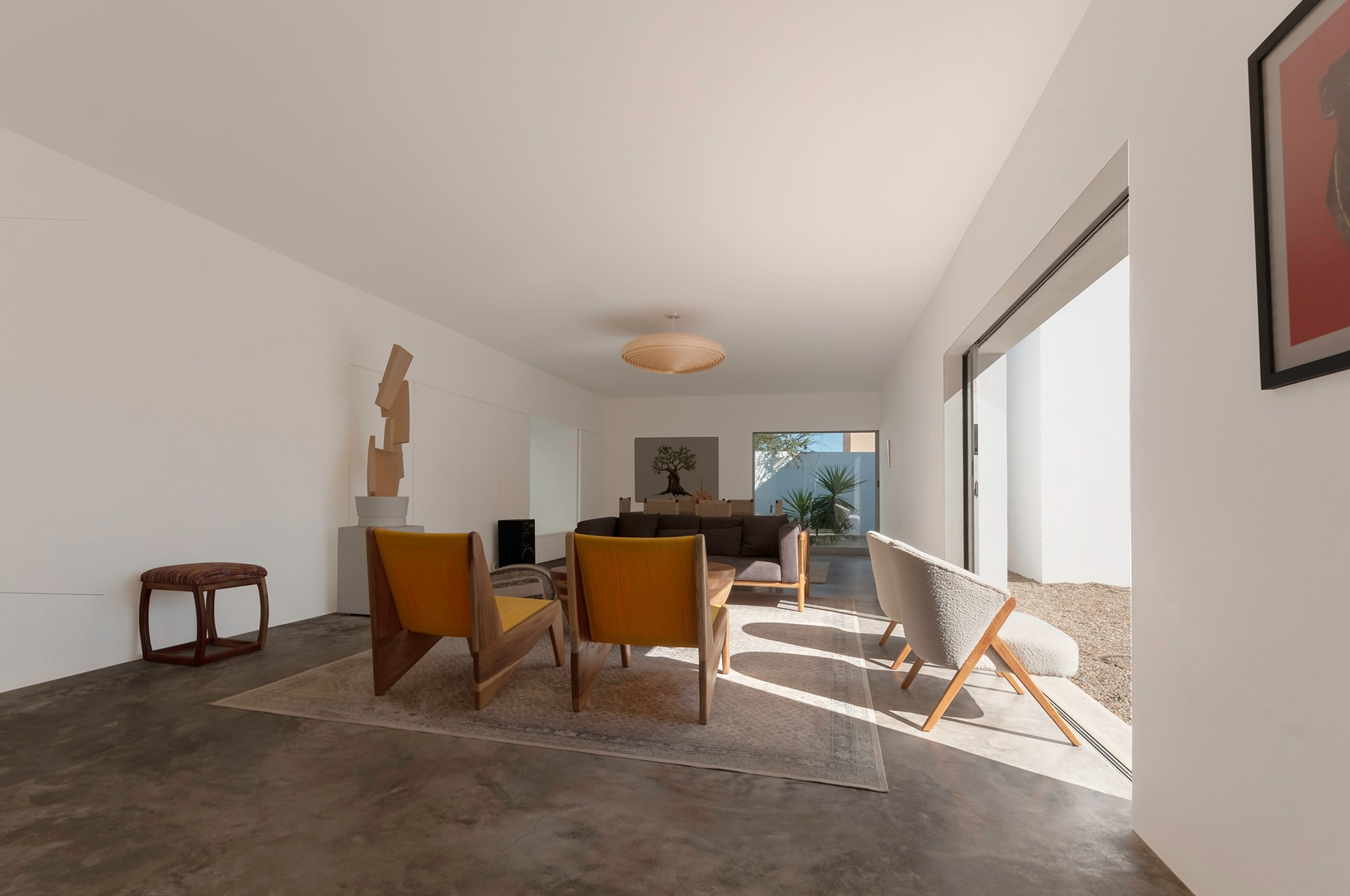 Modern minimalist living room in Los Cabos – bright white interior with sliding glass doors and natural sunlight, high end property photography