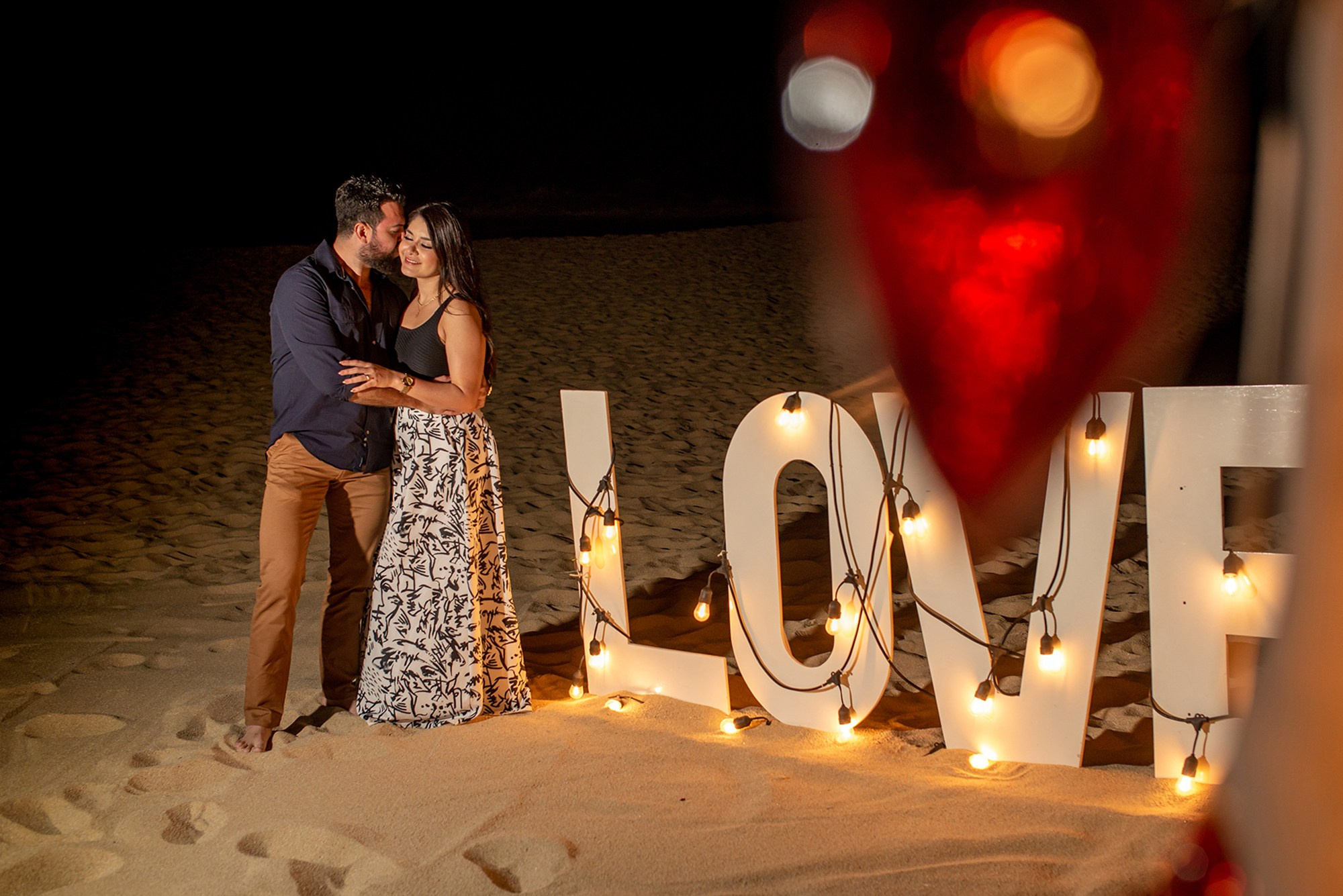 Marriage proposal at Grand Solmar Los Cabos – illuminated LOVE sign on the beach after romantic dinner