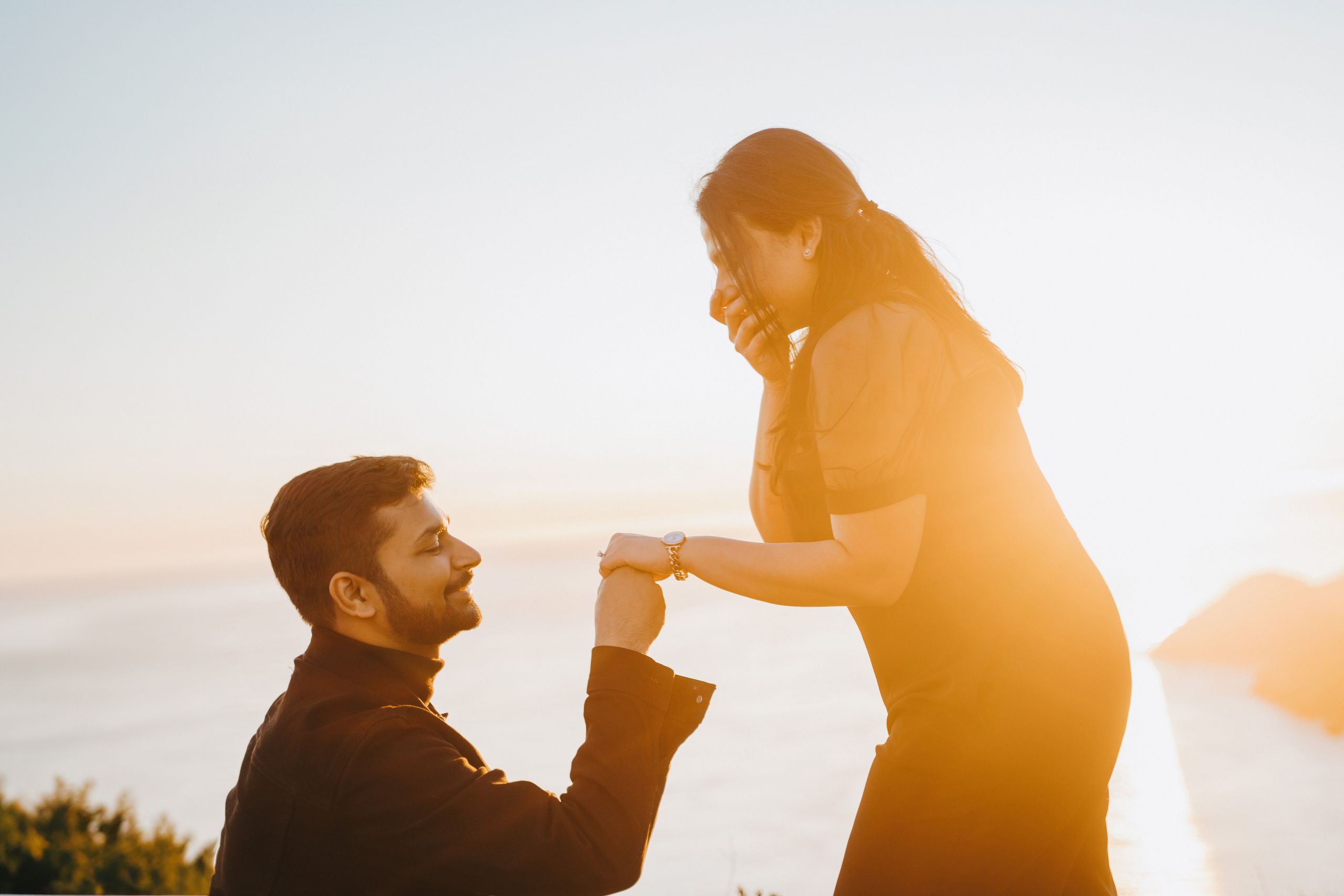 Proposal.  Overlooking the golden San Franisco Bridge sunset with a couple. Photographer Video. 
