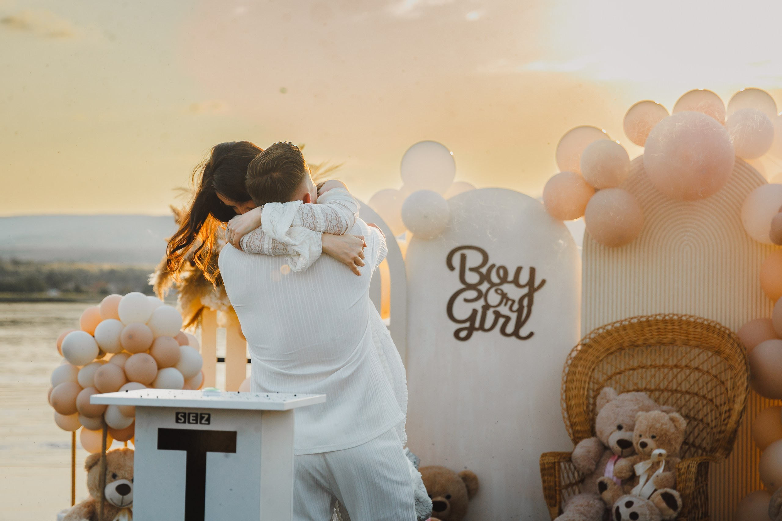 Îmbrățișare caldă după reveal cu semn Boy or Girl în fundal