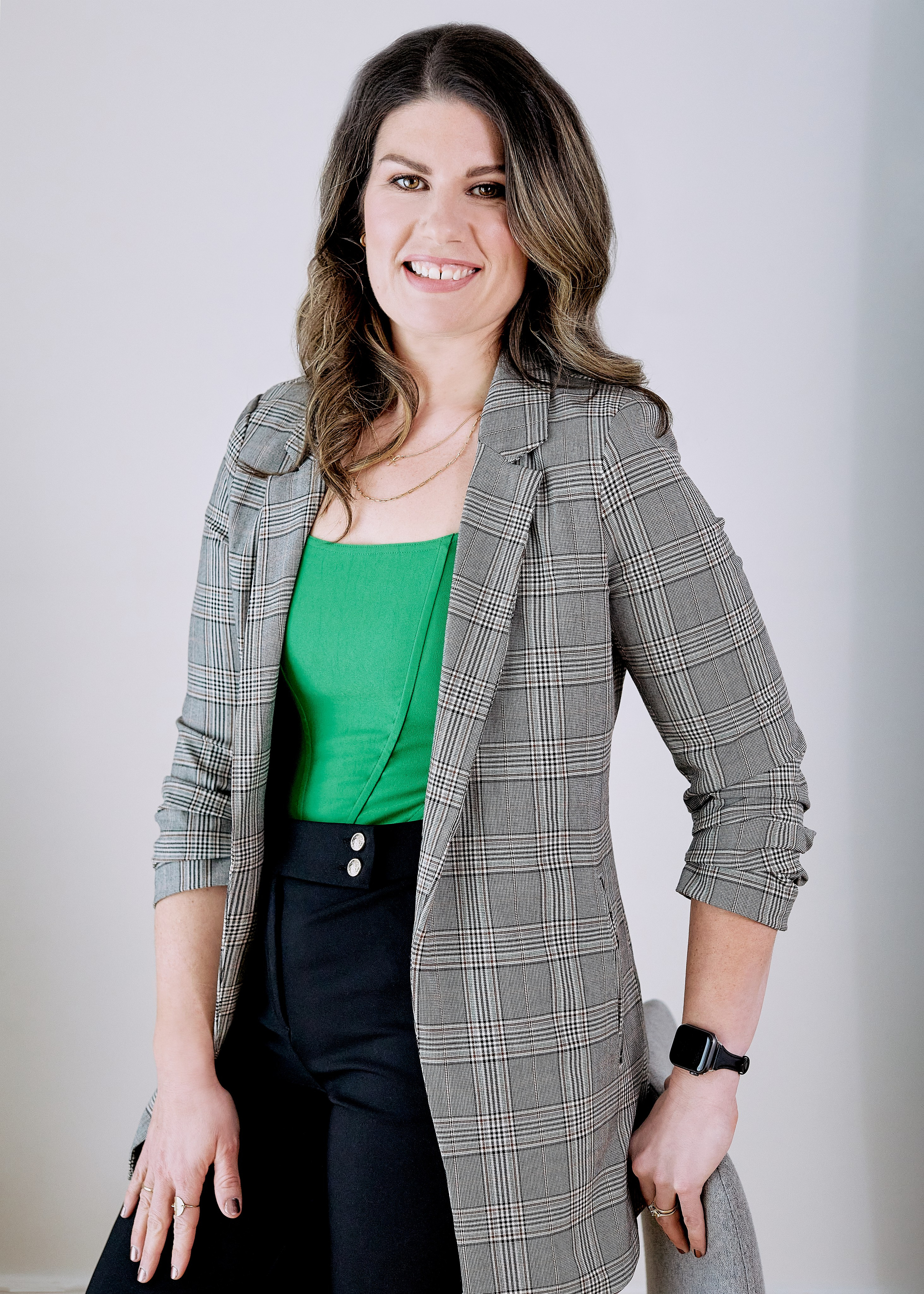 headshot of realtor wearing green top and grey blazer 