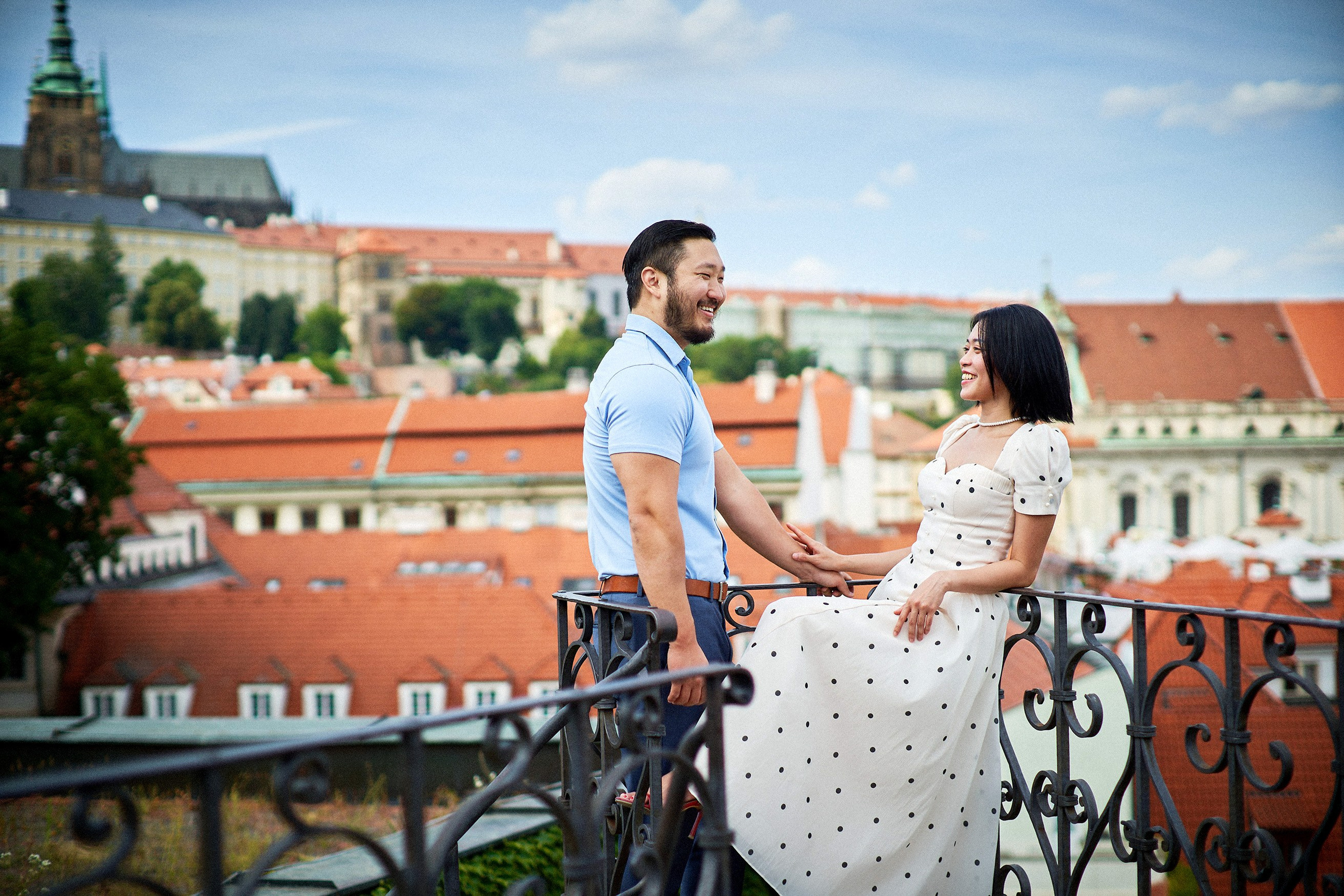 Man smiling as his partner leans back playfully during intimate moment in Vrtba Garden.