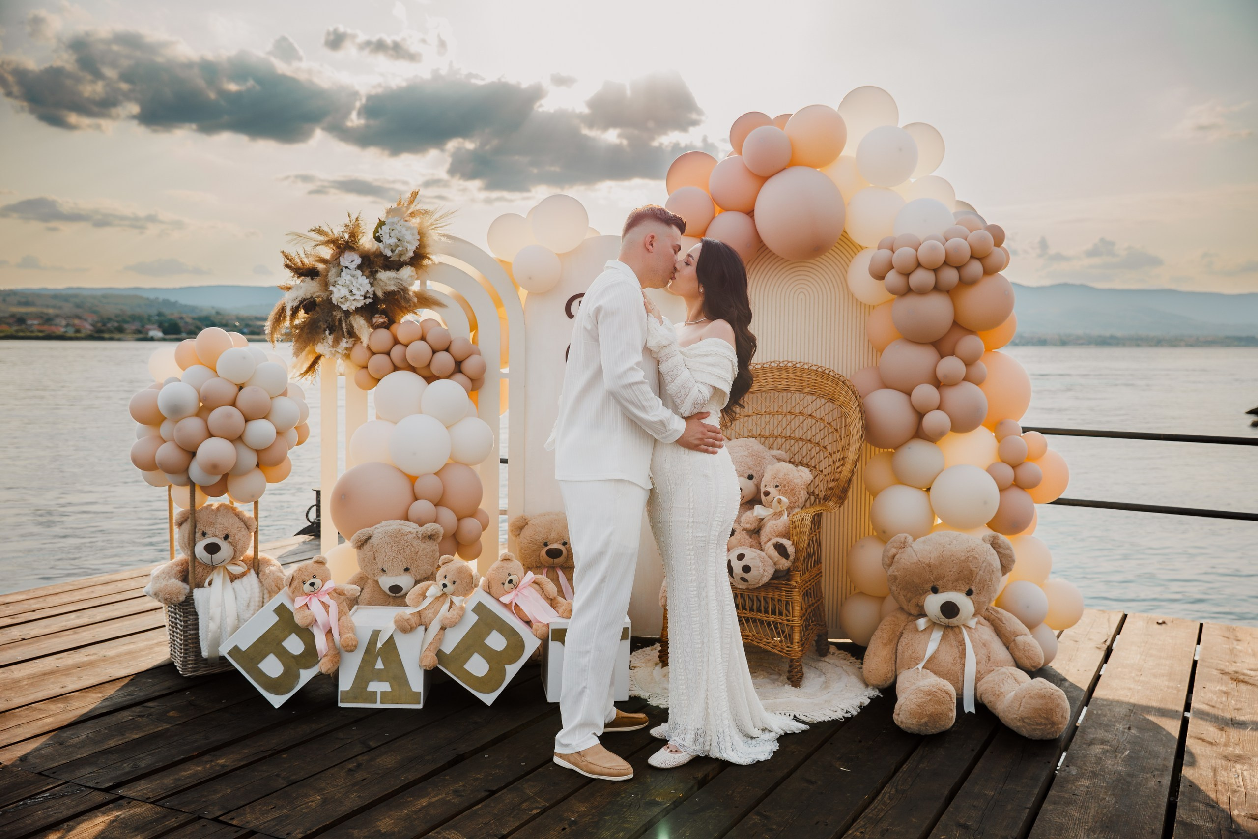 Sărut romantic la apus lângă litere BABY și Dunare