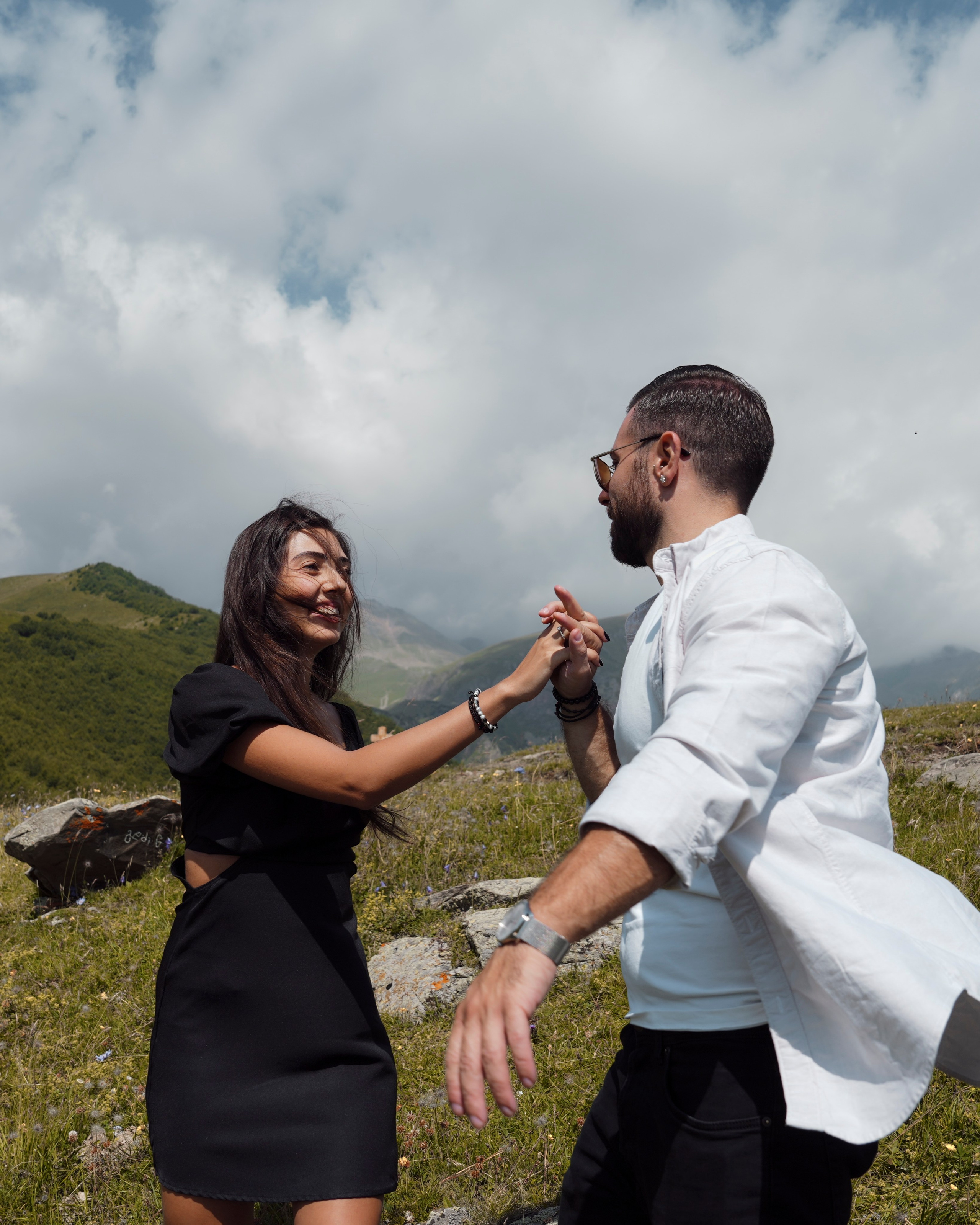 Couple dancing in mountains with dramatic clouds Georgia
