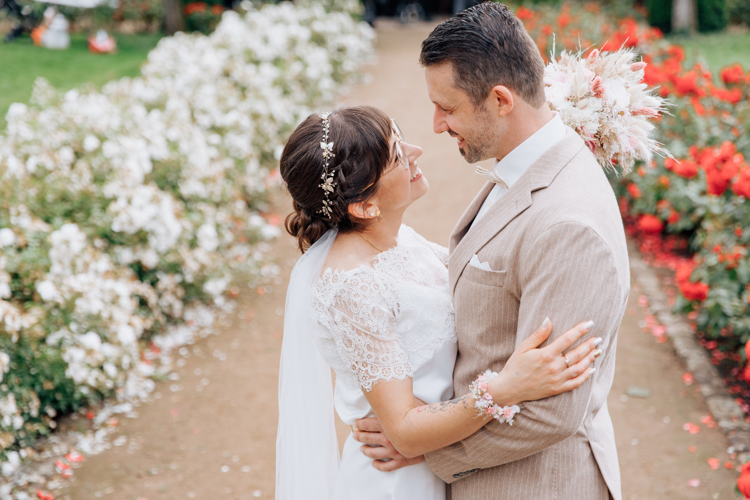 Der Bräutigam und die Braut schauen sich verliebt im Rosengarten Klingenberg an.