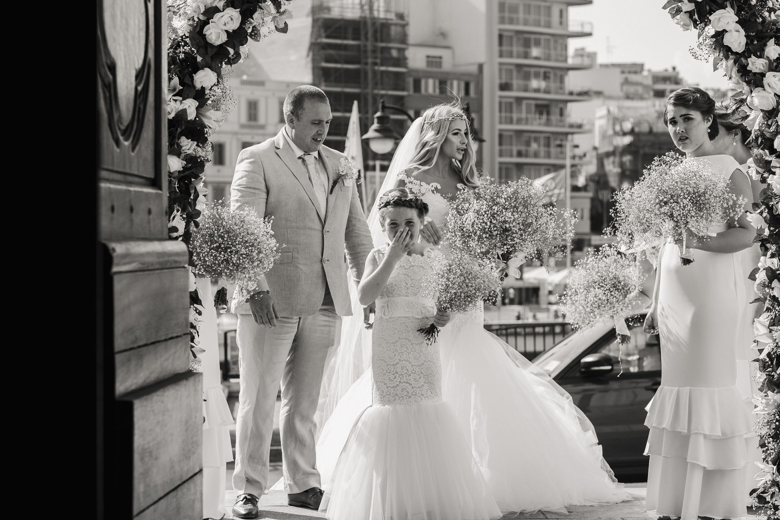 Father of the bride and guests are about to enter the cathedral for a wedding ceremony