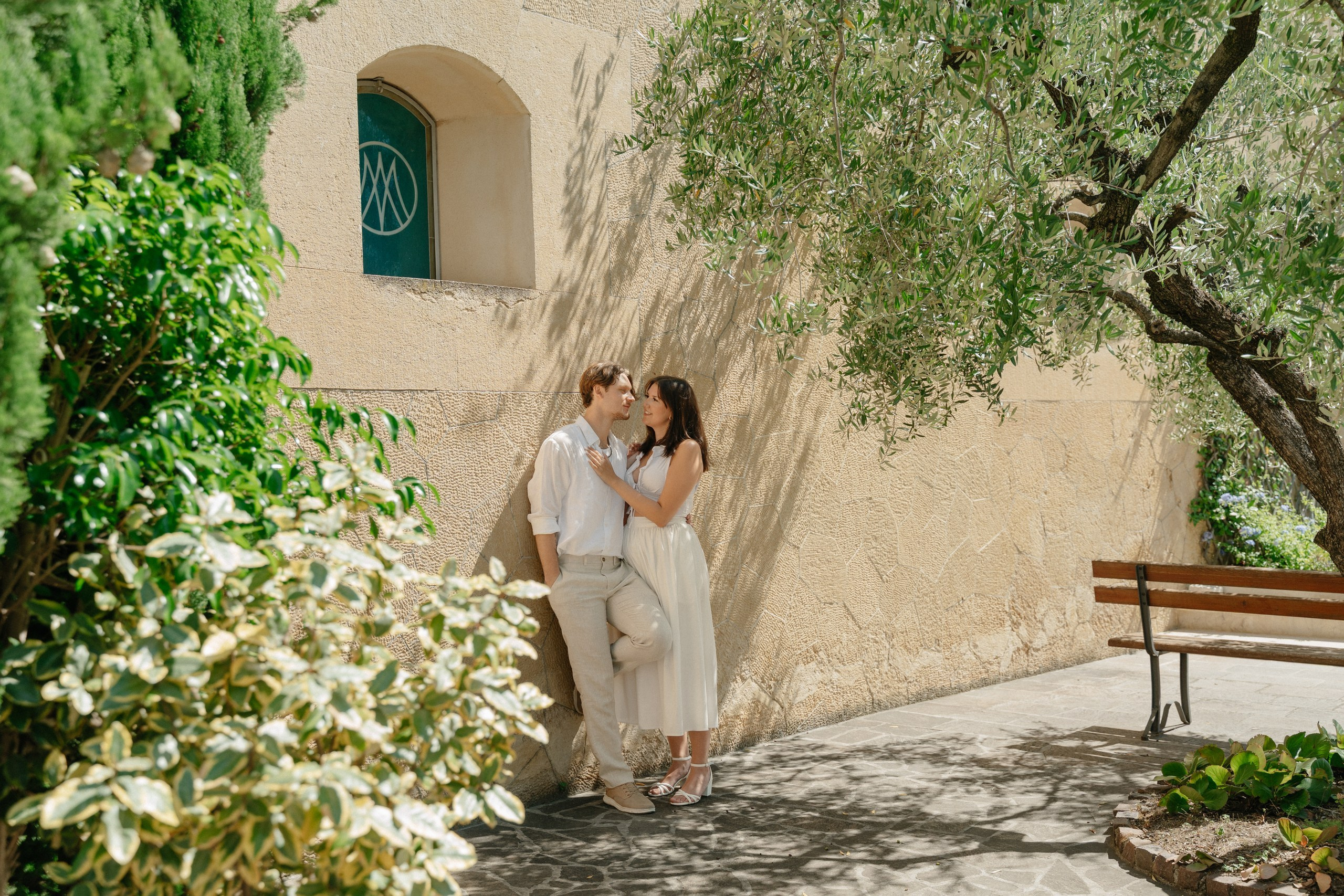 Couple sharing a kiss after a surprise proposal with panoramic views of Verona.