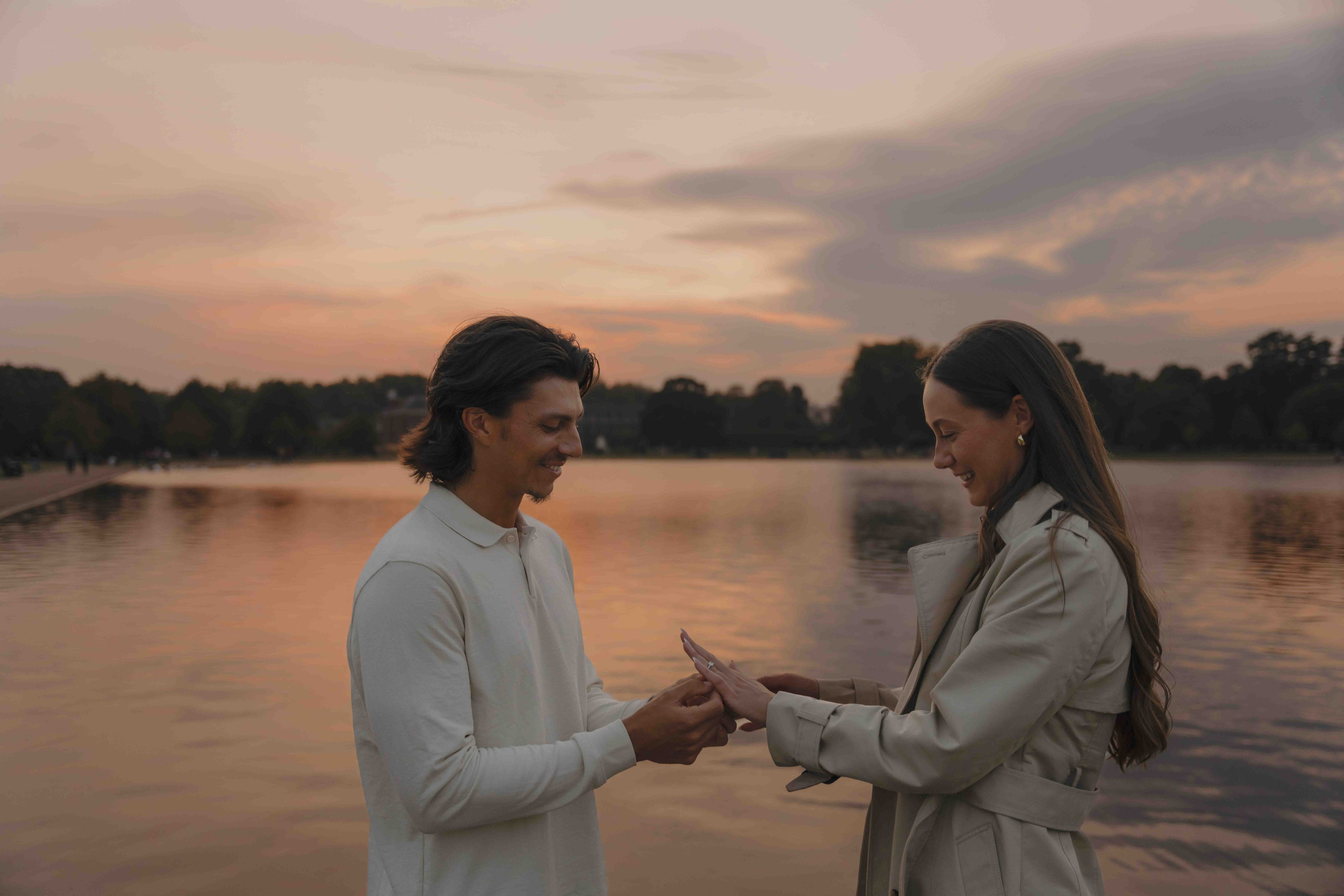 Man proposing in Kensington Gardens London at sunset near lake