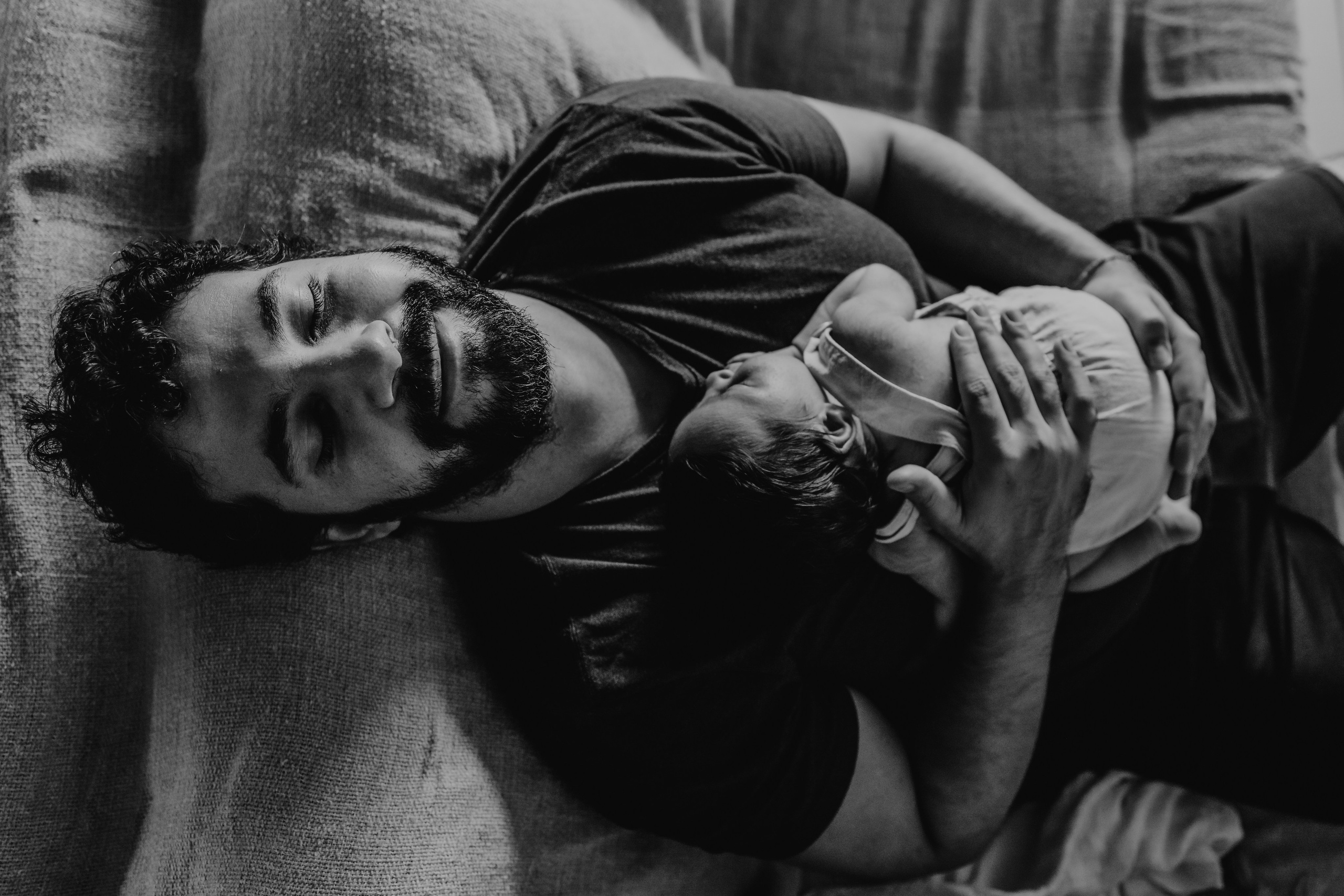 Pai com bebê no colo sorrindo em momento de felicidade