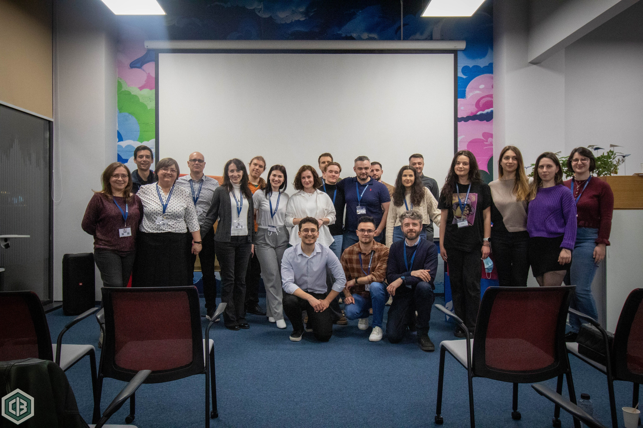 Group of people gathered in a conference-style room during an indoor event.
