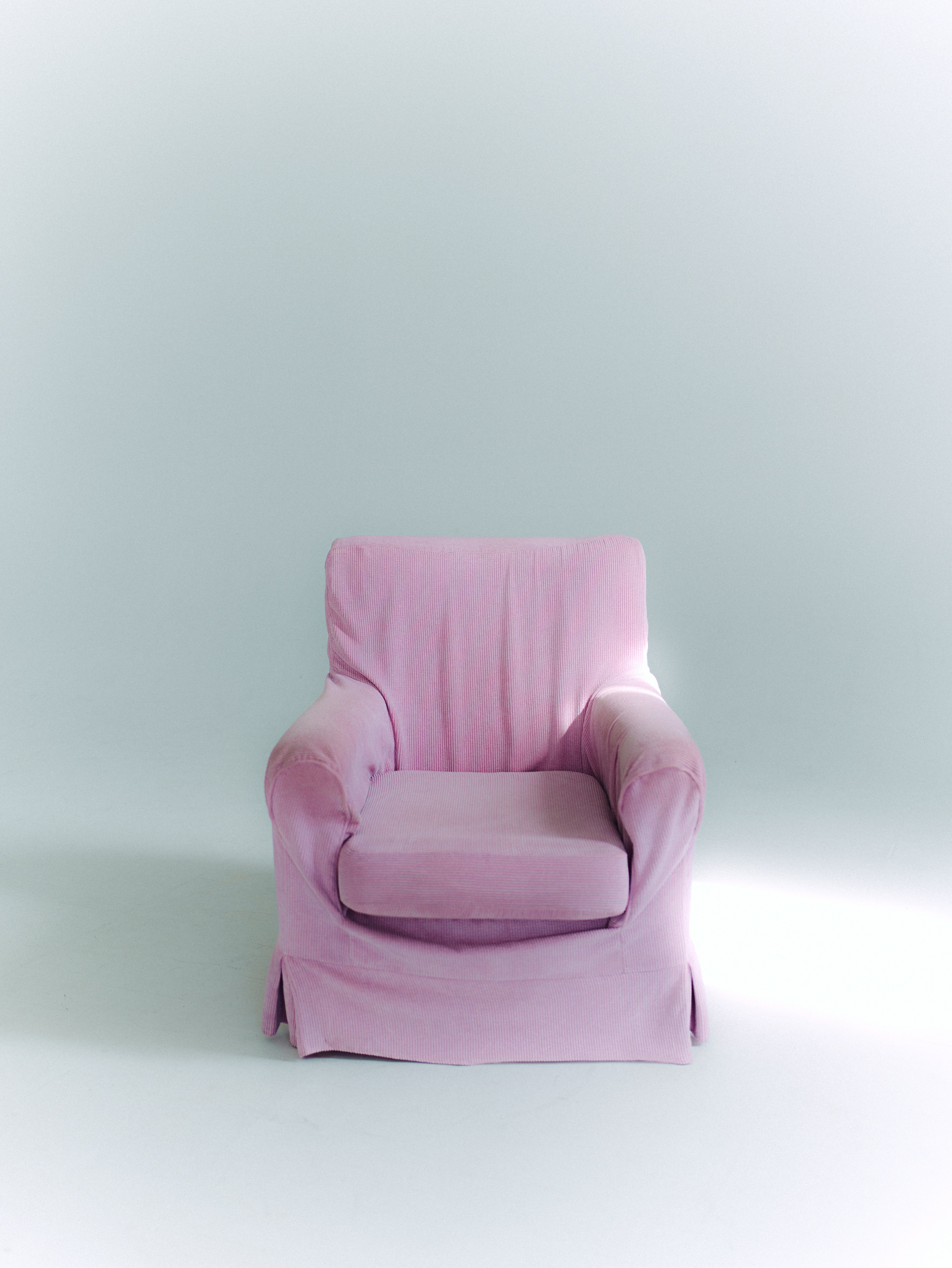 Pink pastel armchair in a bright minimal photography studio