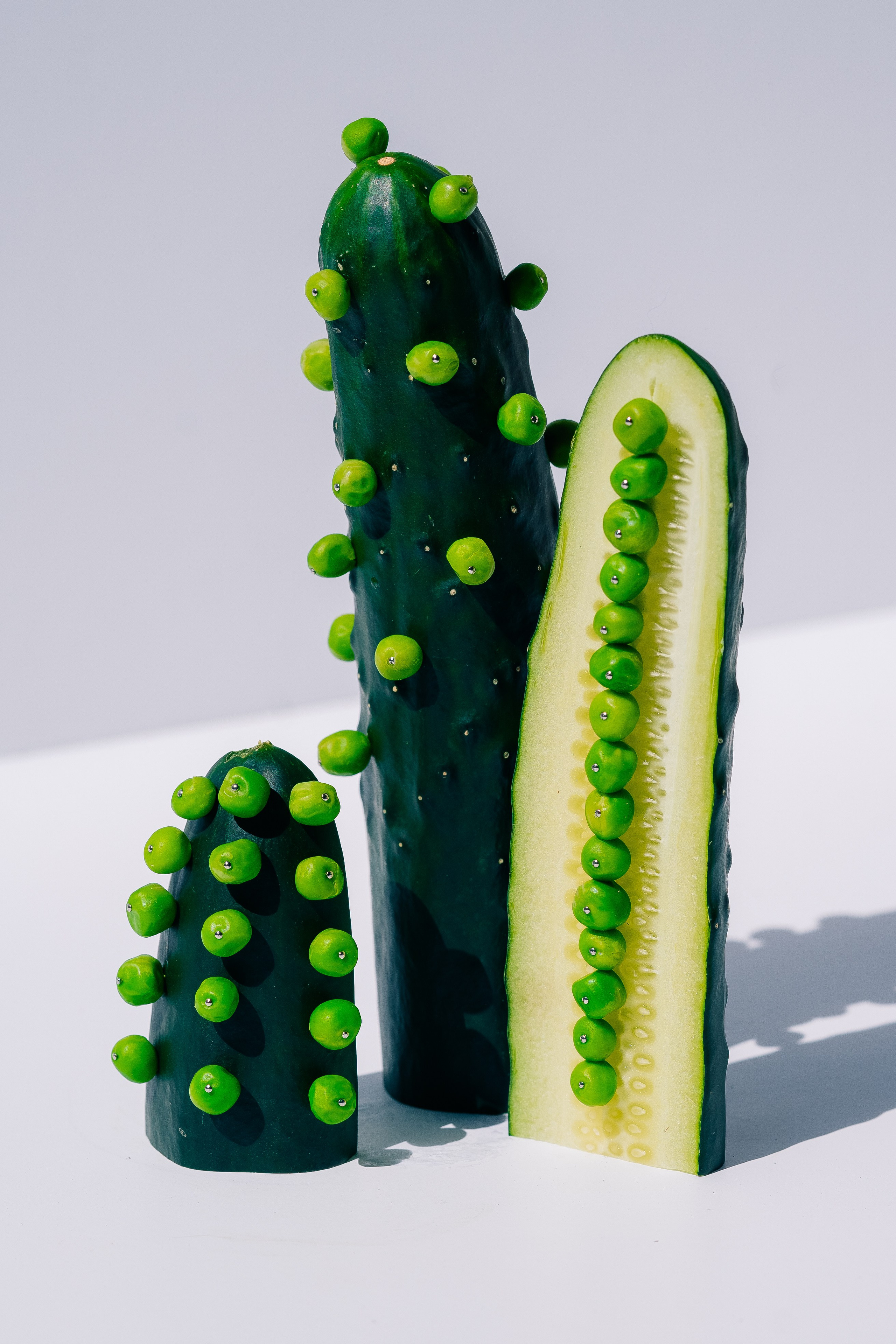Abstract Composition of Cucumbers and Peas.  A surreal arrangement of cucumbers and peas in an artistic, minimalistic style on a light background.