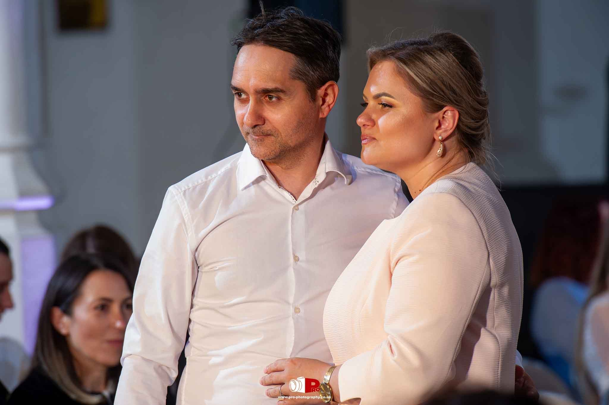 A couple posing warmly during a formal gala event dressed elegantly.
