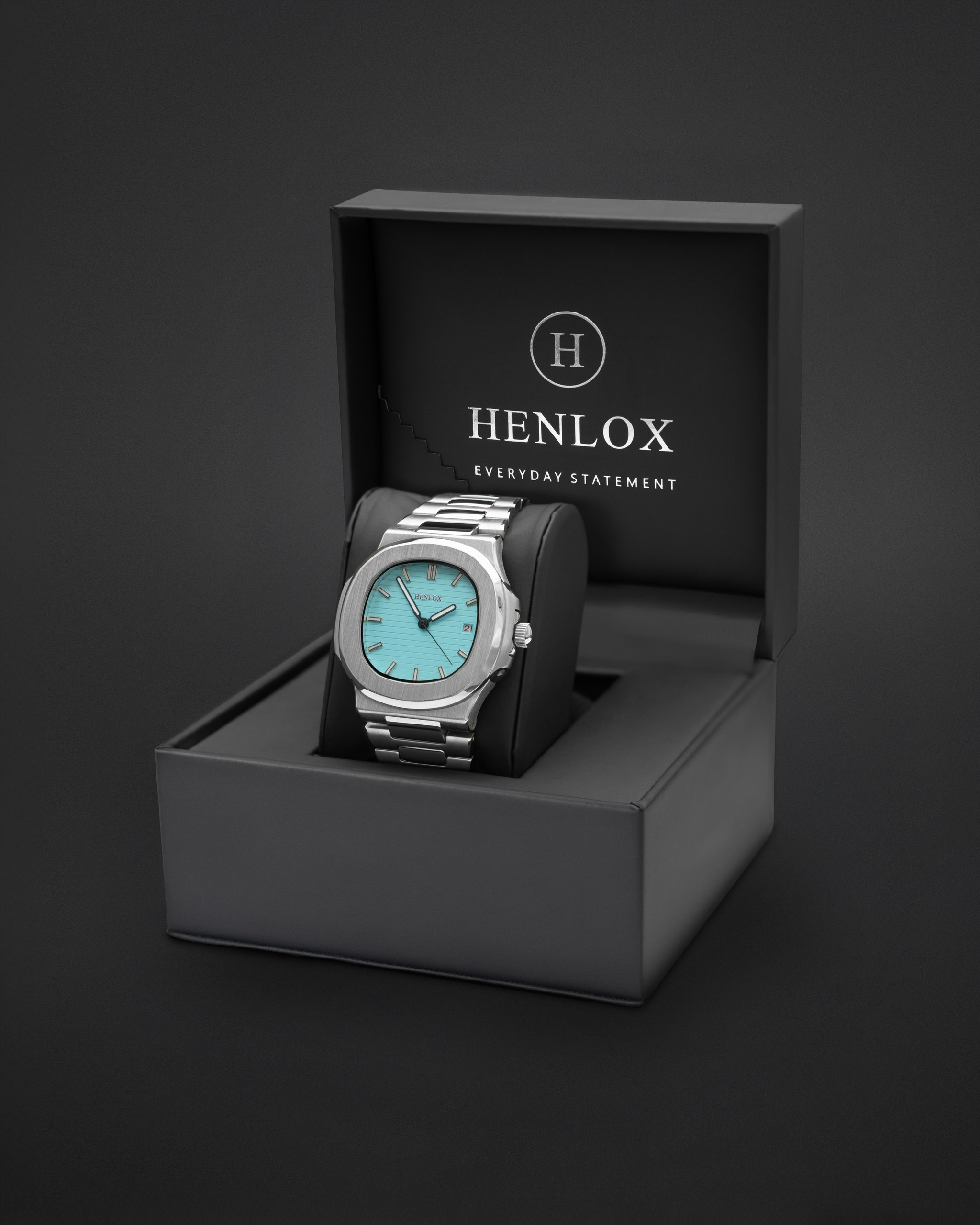 Elegant silver watch presented in its black packaging for product photography