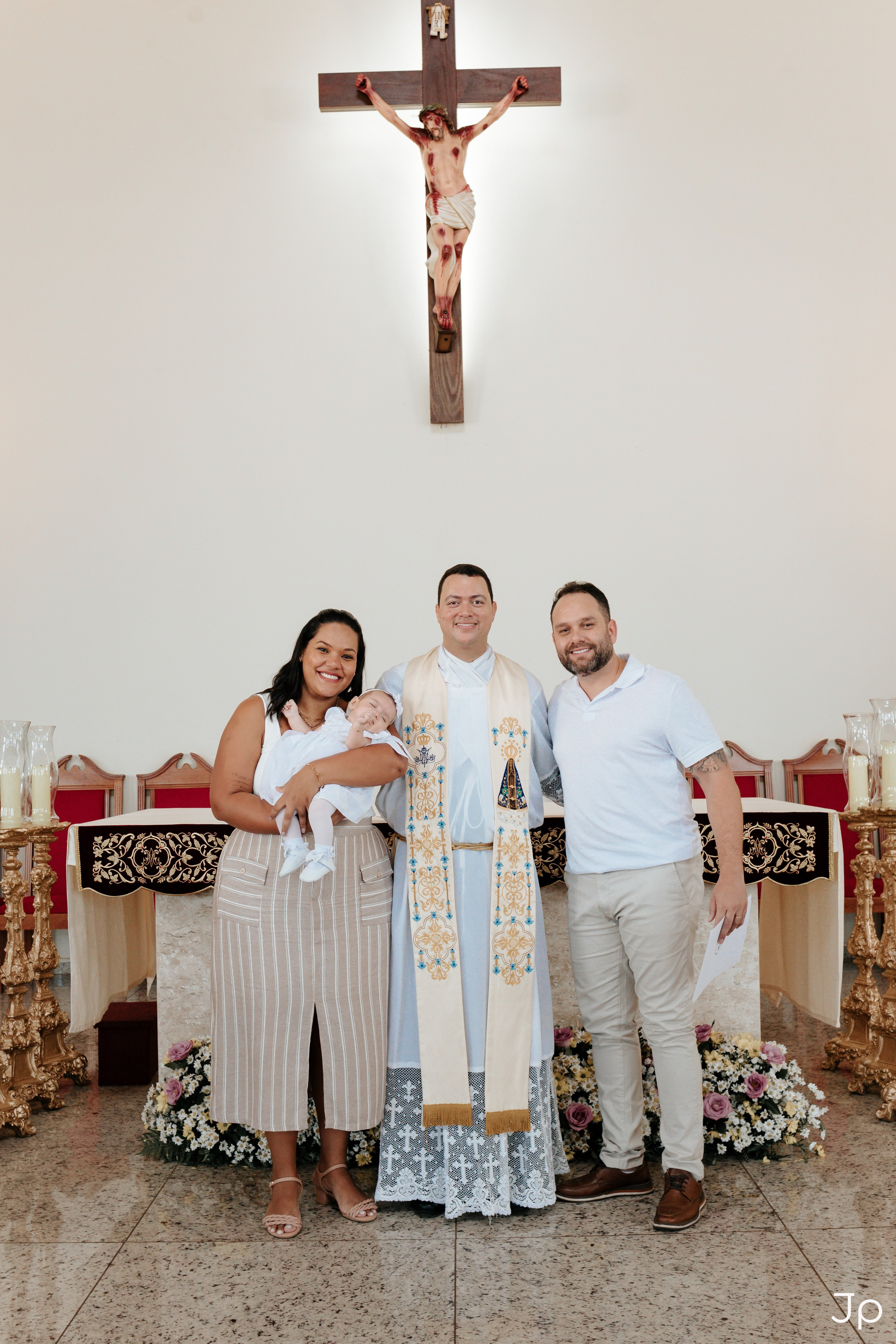 Família no altar com o crucifixo ao fundo.