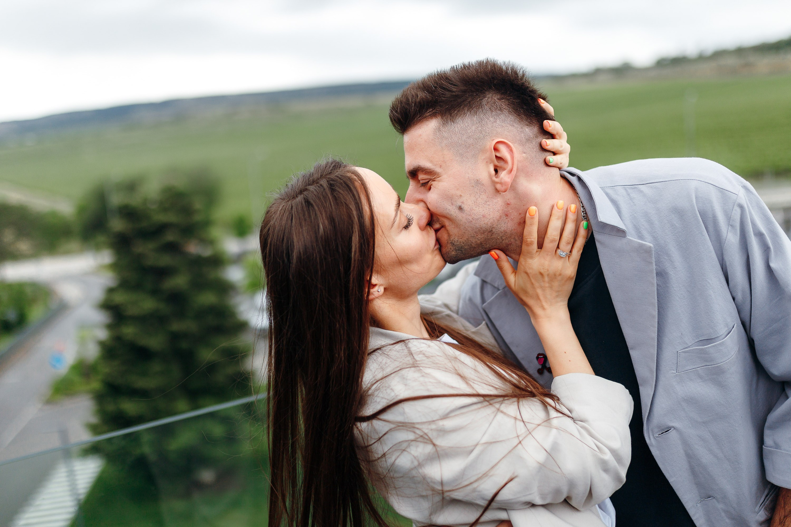 Couple kissing outdoors, romantic engagement shoot