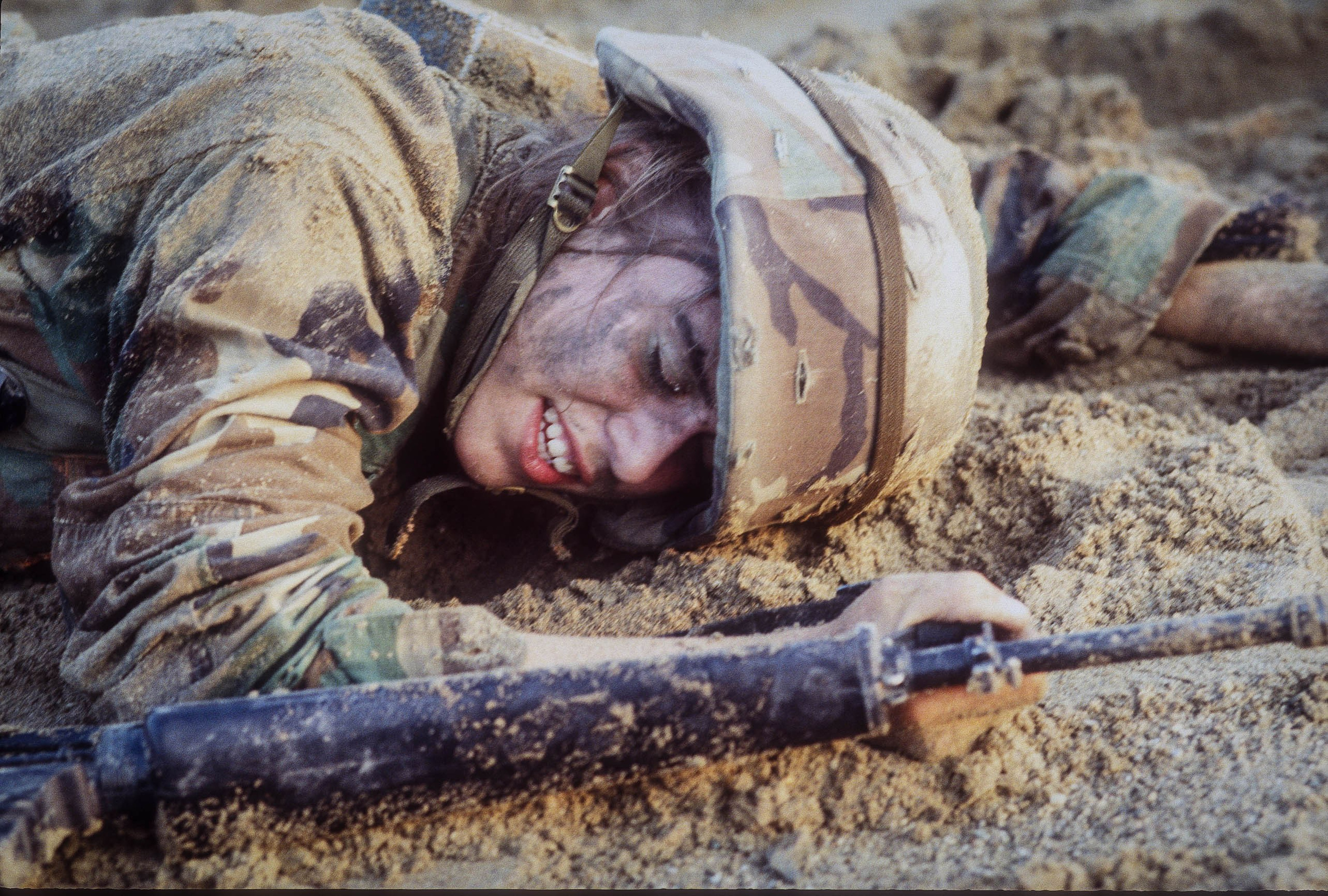 A US female soldier struggles with crawling under the wire with her weapon during training at an undisclosed location as part of NATO training.