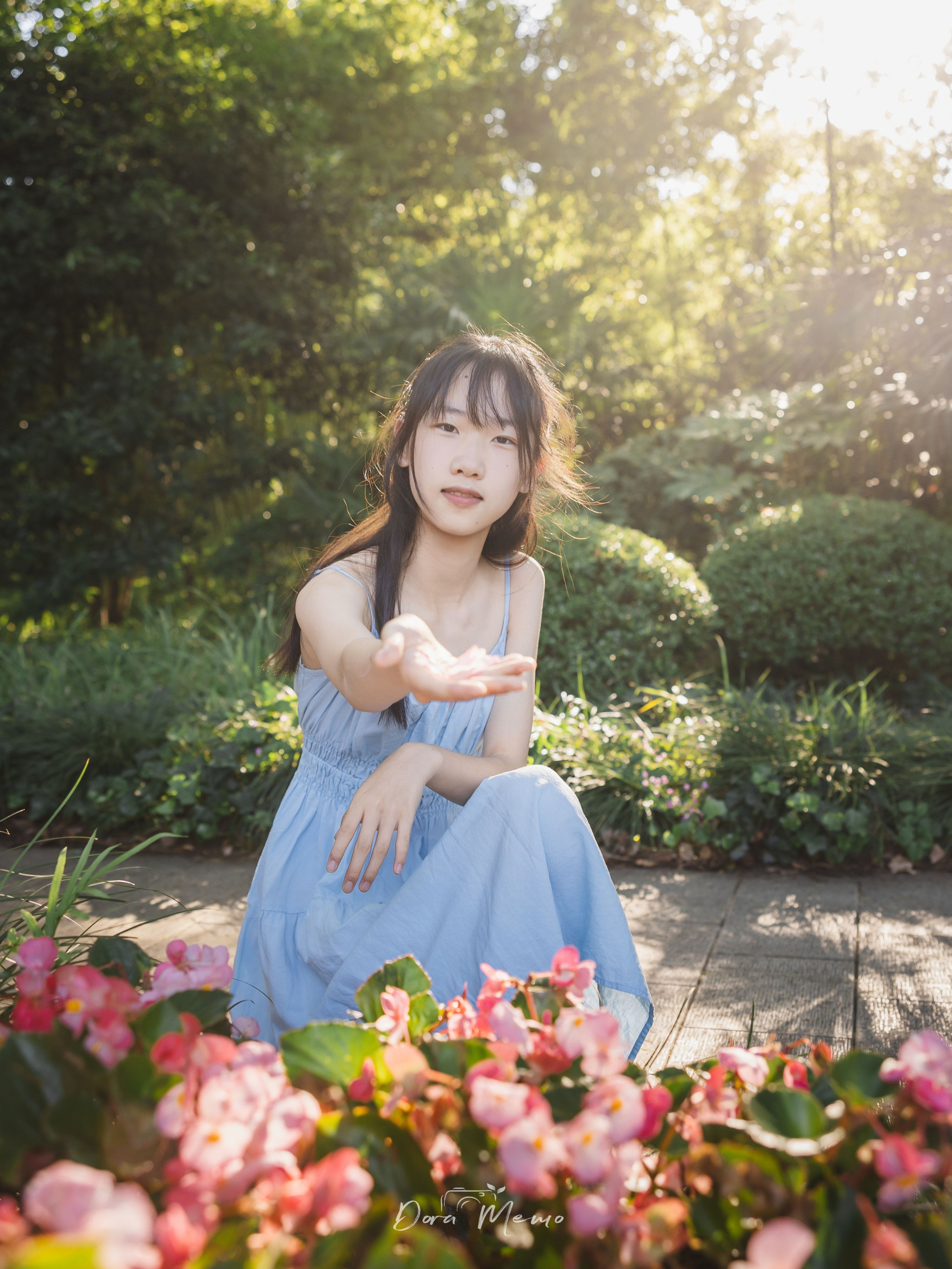 Crouching in a garden, soft golden front light | Crouching in a garden, a 14-year-old bathed in warm afternoon light