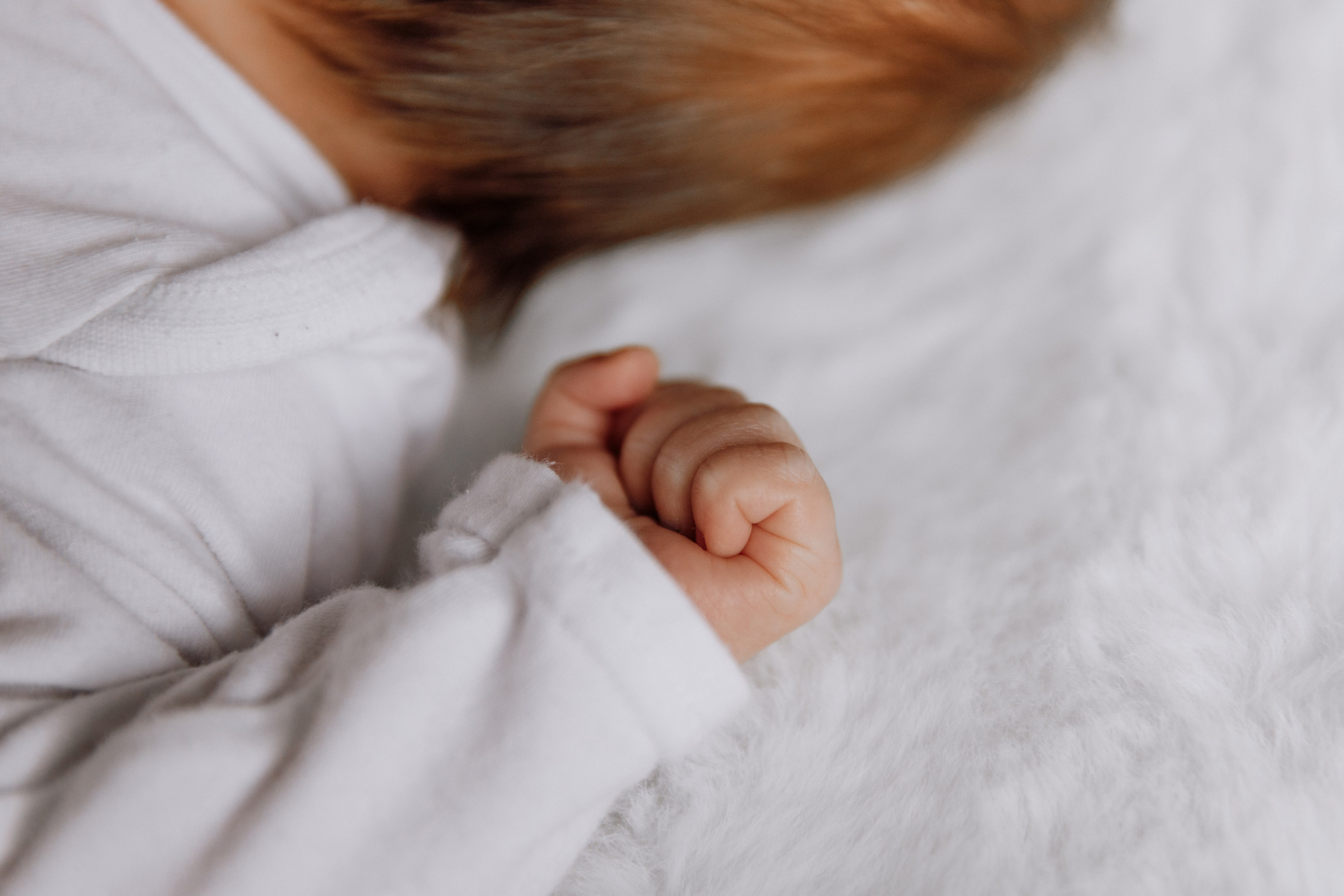 Babyhand ist zu einer kleinen Faust geballt.