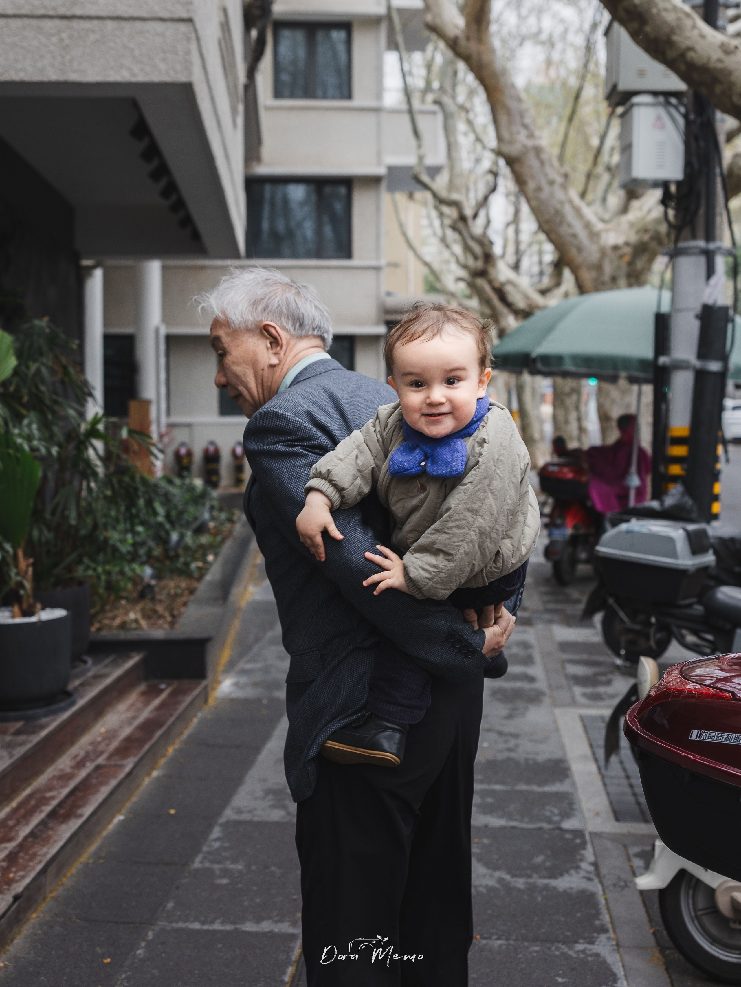 On the streets of Shanghai, the baby is taking a walk and playing with grandpa.