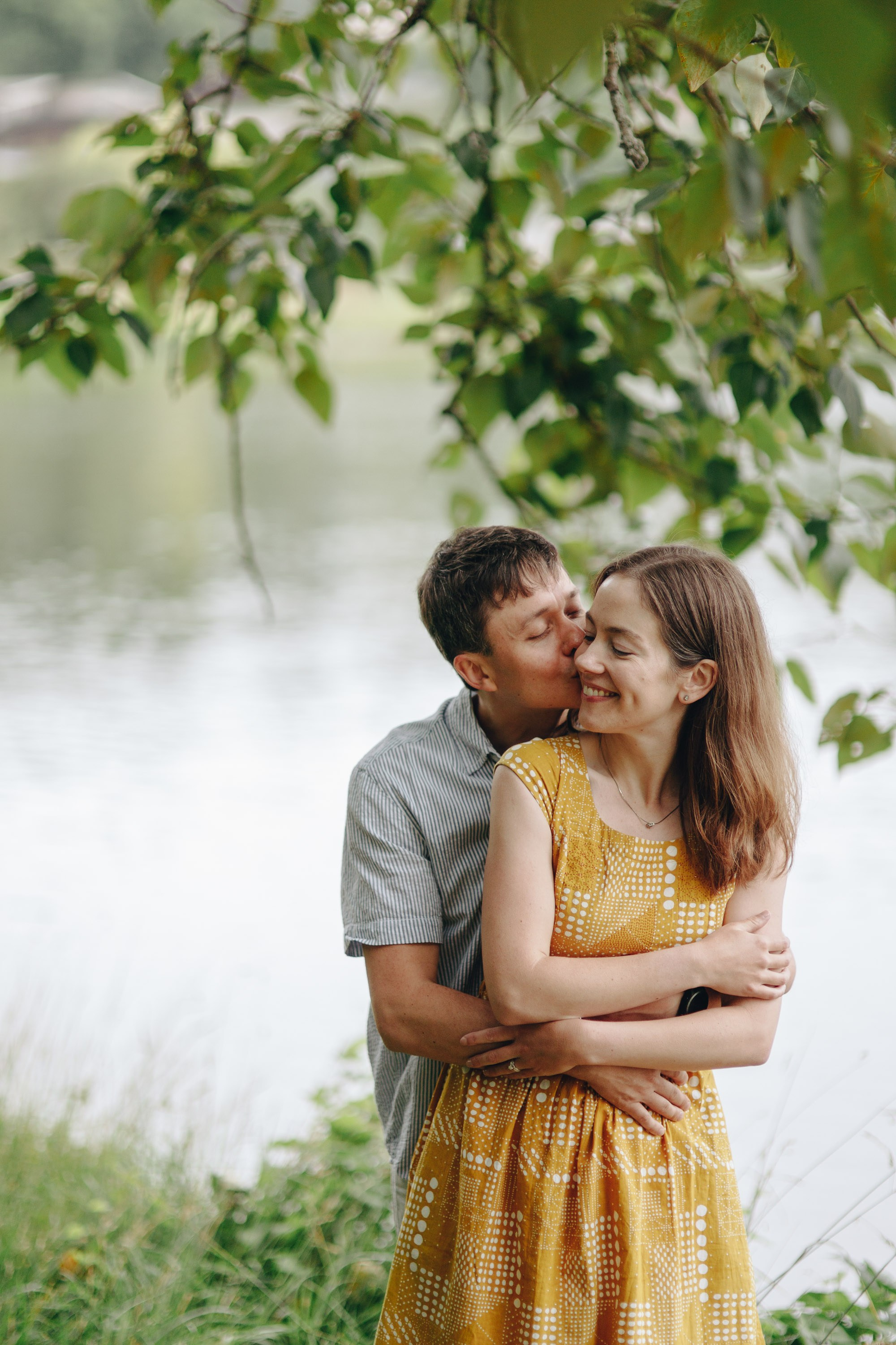 Couple embracing by lake, dreamy engagement session